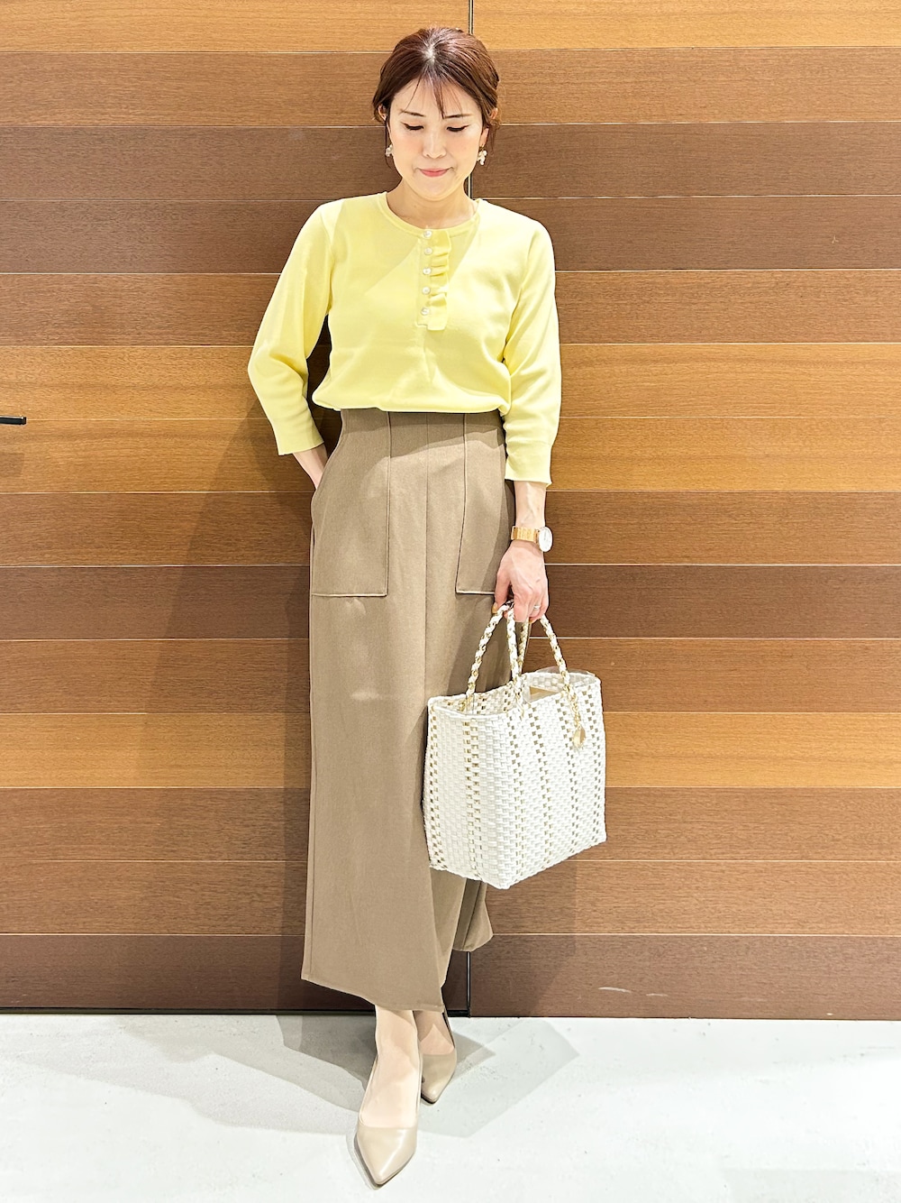 ベージュ系のパンプス、ベージュ系のショルダーバッグ、ブラウン系のスカートを着用したレディースの春コーディネートの4枚目の写真