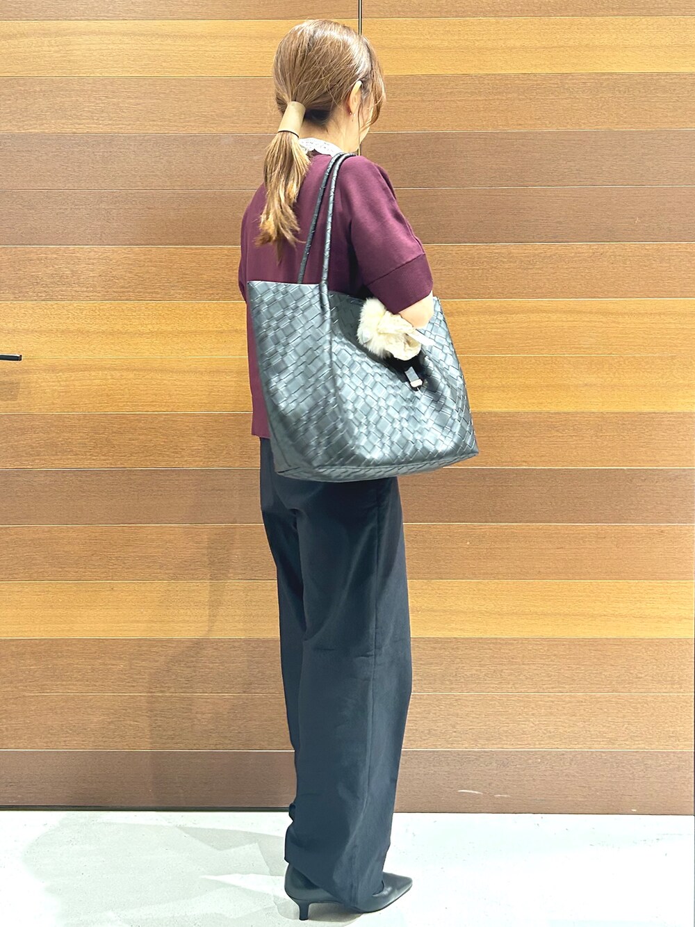 レッド系のニット/セーター、ブラック系のその他パンツ、ブラック系のトートバッグを着用したレディースの秋コーディネートの5枚目の写真