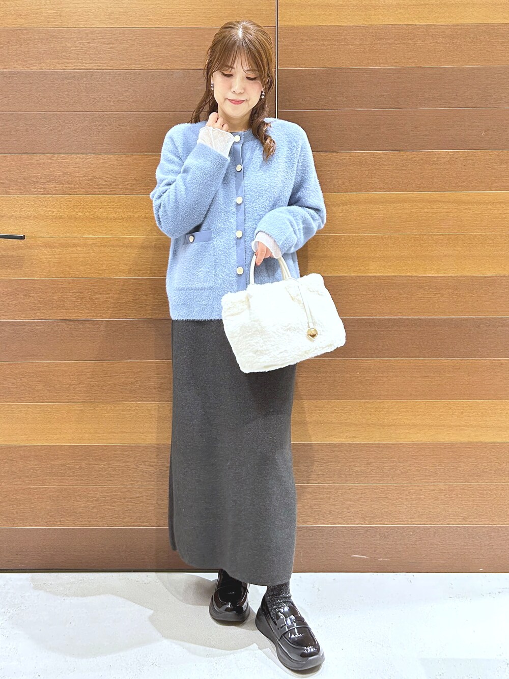 ブルー系のカーディガン/ボレロ、グレー系のTシャツ/カットソー、グレー系のスカートを着用したレディースの秋コーディネートの4枚目の写真