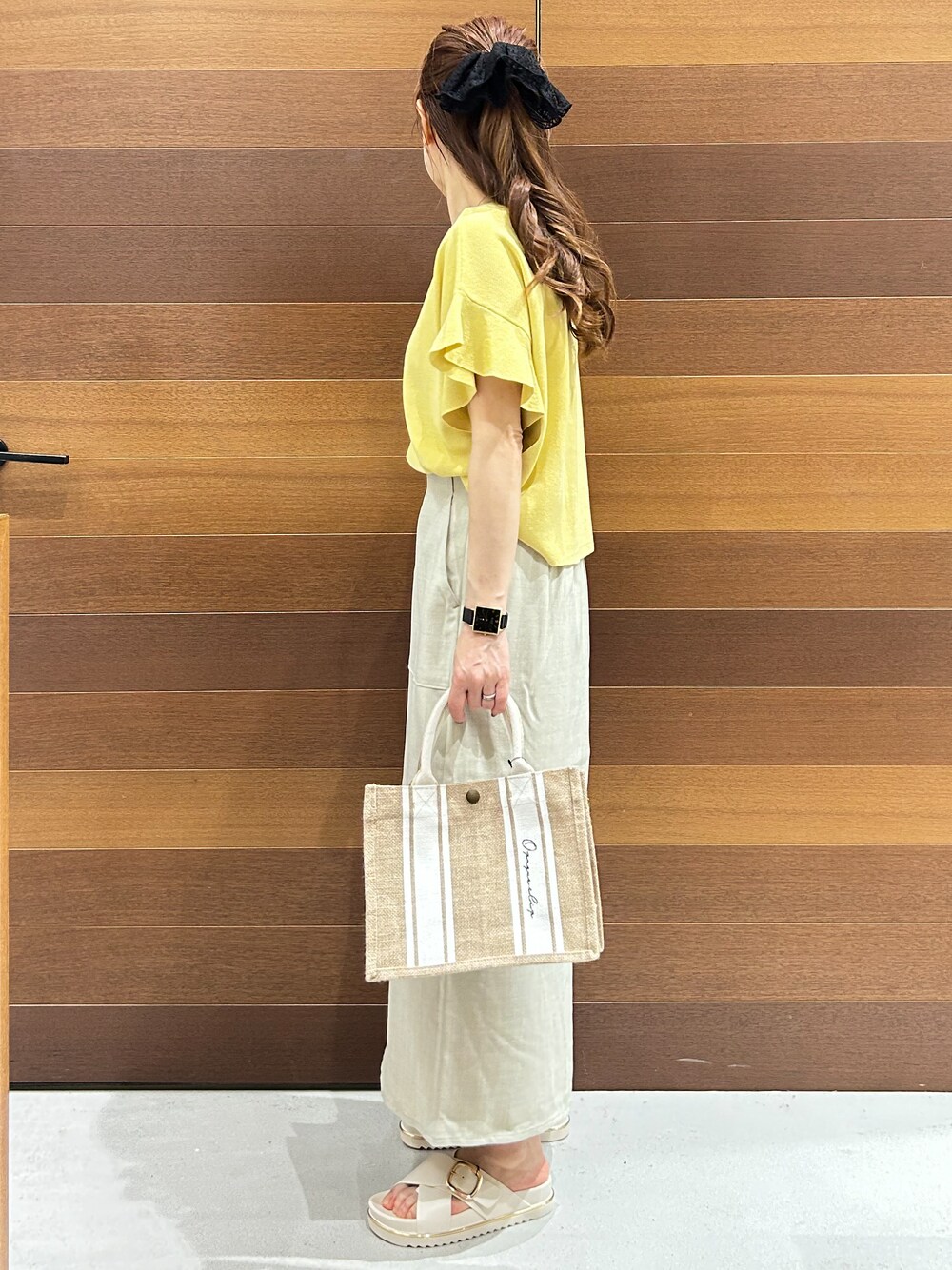 ホワイト系のトートバッグ、ベージュ系のスカート、ホワイト系のサンダルを着用したレディースの春コーディネートの5枚目の写真
