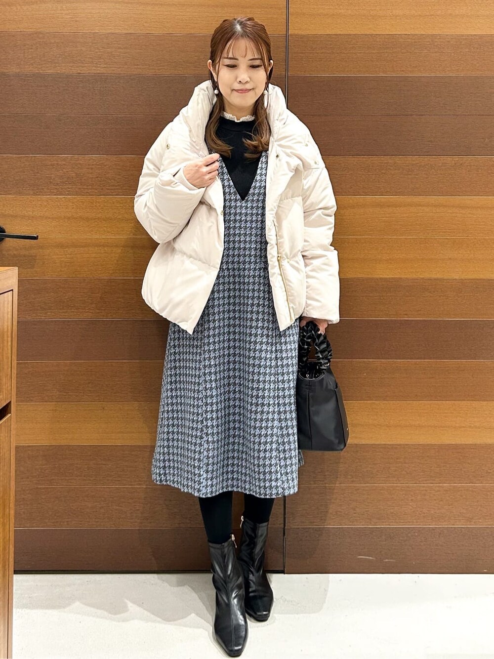 ベージュ系のダウンジャケット/コート、ブラック系のニット/セーター、ブルー系のワンピースを着用したレディースの冬コーディネートの7枚目の写真