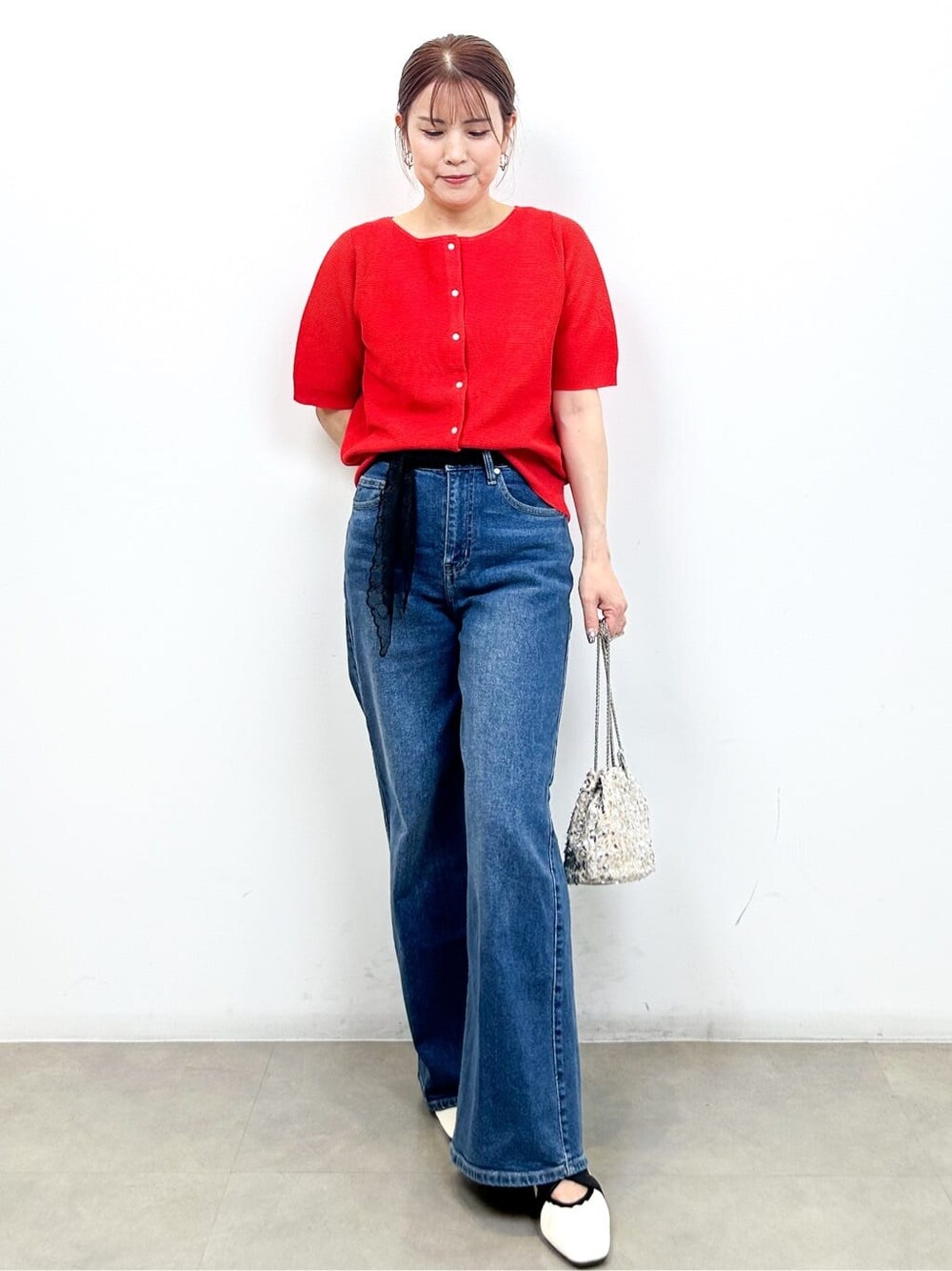 レッド系のカーディガン/ボレロ、ブルー系のデニムパンツ、ホワイト系のショルダーバッグを着用したレディースの夏コーディネートの5枚目の写真