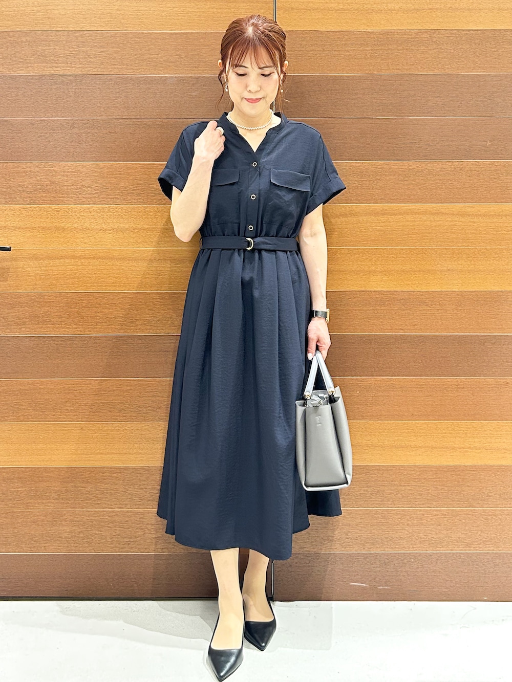 ブルー系のワンピース、ベージュ系のトートバッグ、ブラック系のパンプスを着用したレディースの夏コーディネートの3枚目の写真