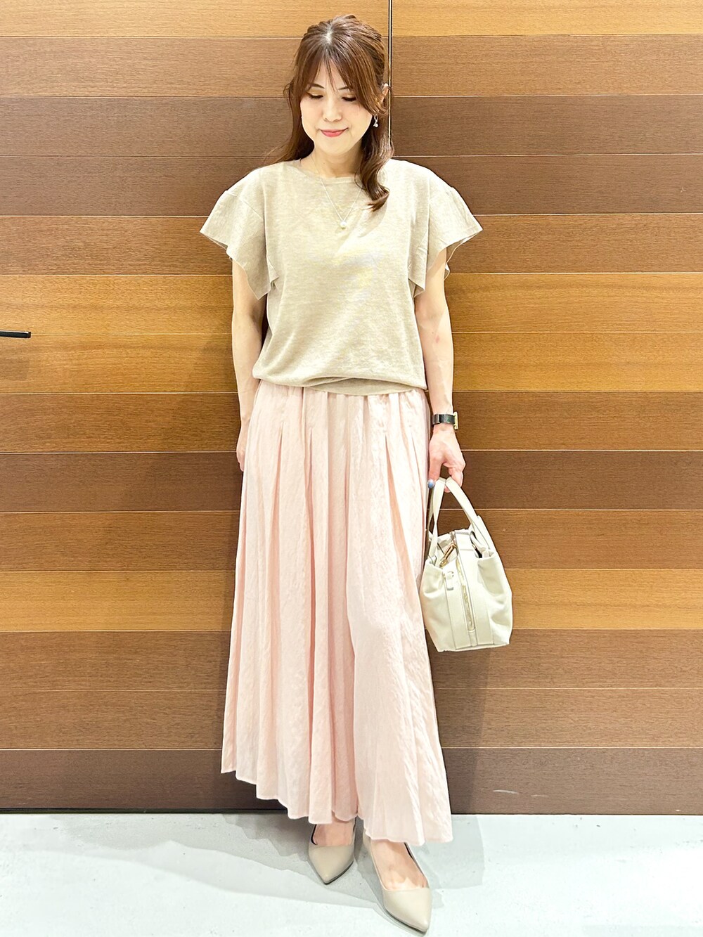 ベージュ系のニット/セーター、ピンク系のその他パンツ、グレー系のボストンバッグを着用したレディースの夏コーディネートの2枚目の写真