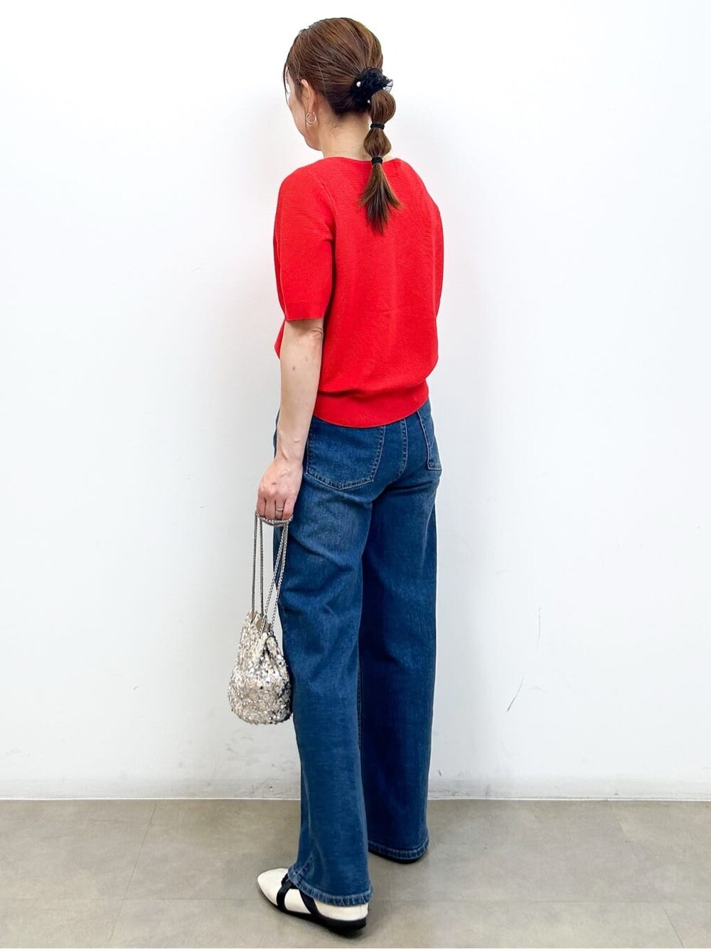 レッド系のカーディガン/ボレロ、ブルー系のデニムパンツ、ホワイト系のショルダーバッグを着用したレディースの夏コーディネートの7枚目の写真