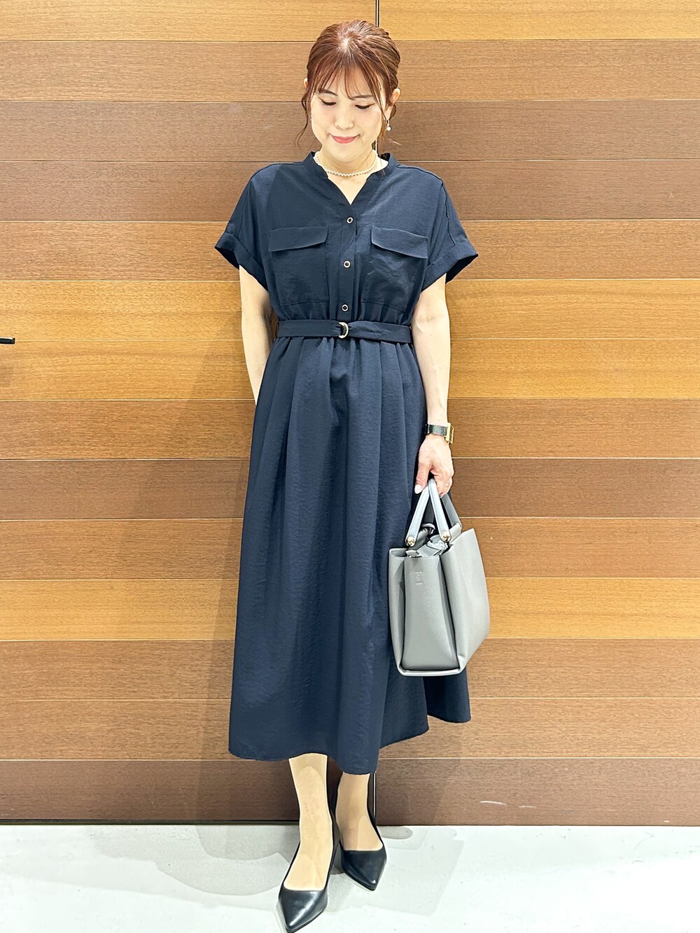 ブルー系のワンピース、グレー系のトートバッグ、ブラック系のパンプスを着用したレディースの夏コーディネートの7枚目の写真