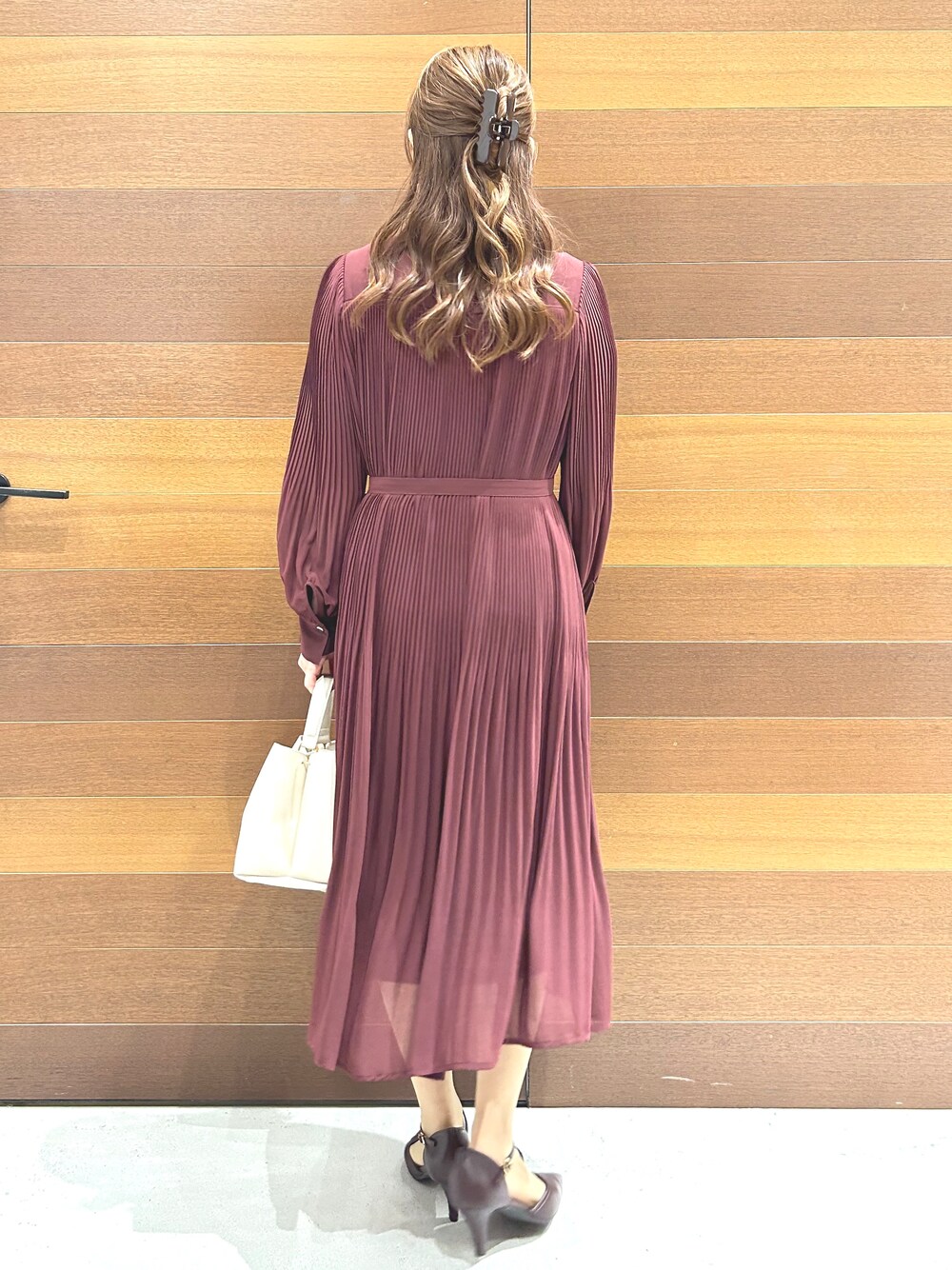 レッド系のワンピース、ホワイト系のハンドバッグ、レッド系のパンプスを着用したレディースの秋コーディネートの6枚目の写真