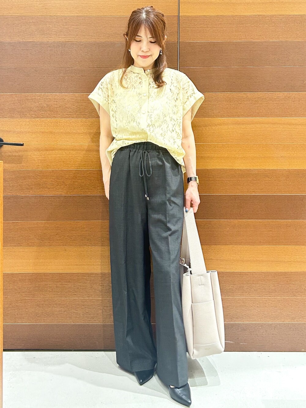 イエロー系のシャツ/ブラウス、グレー系のその他パンツ、グレー系のトートバッグを着用したレディースの夏コーディネートの2枚目の写真