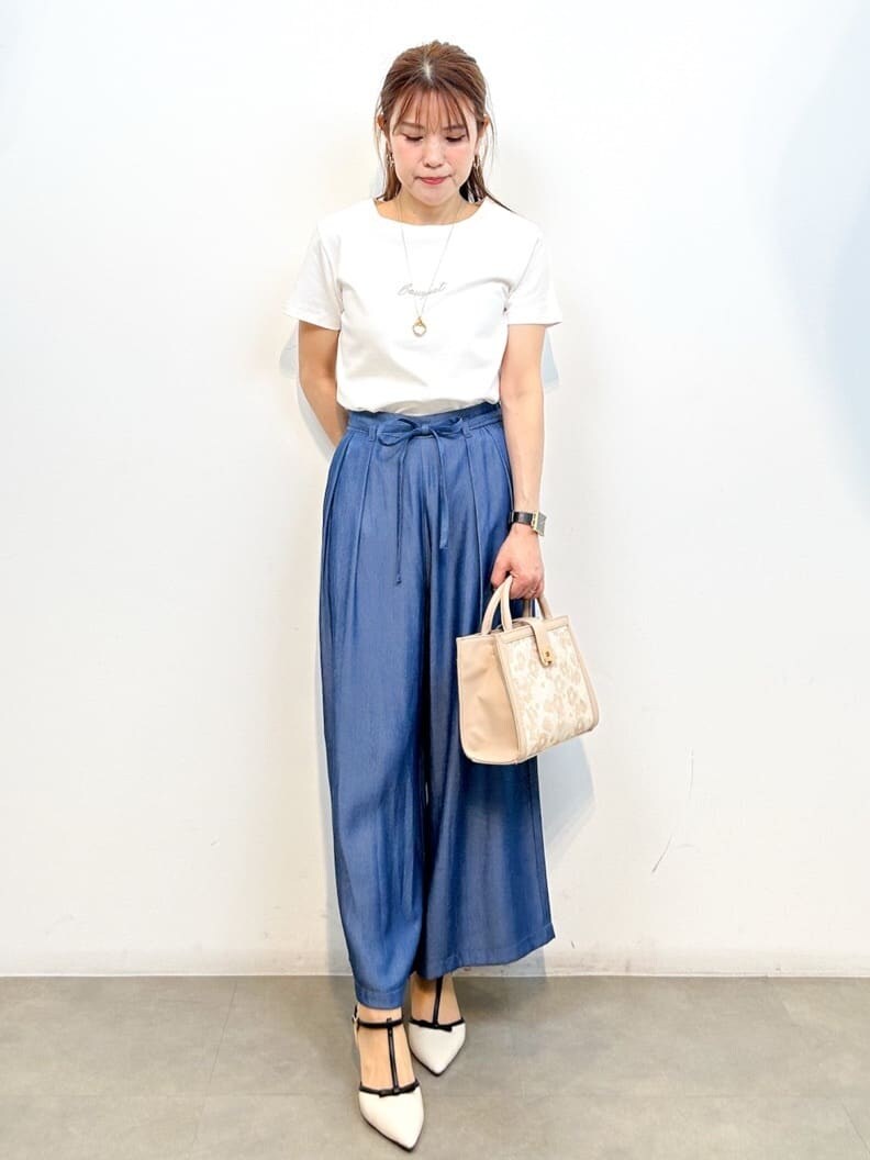 ホワイト系のTシャツ/カットソー、ブルー系のその他パンツ、ベージュ系のショルダーバッグを着用したレディースの春コーディネートの3枚目の写真