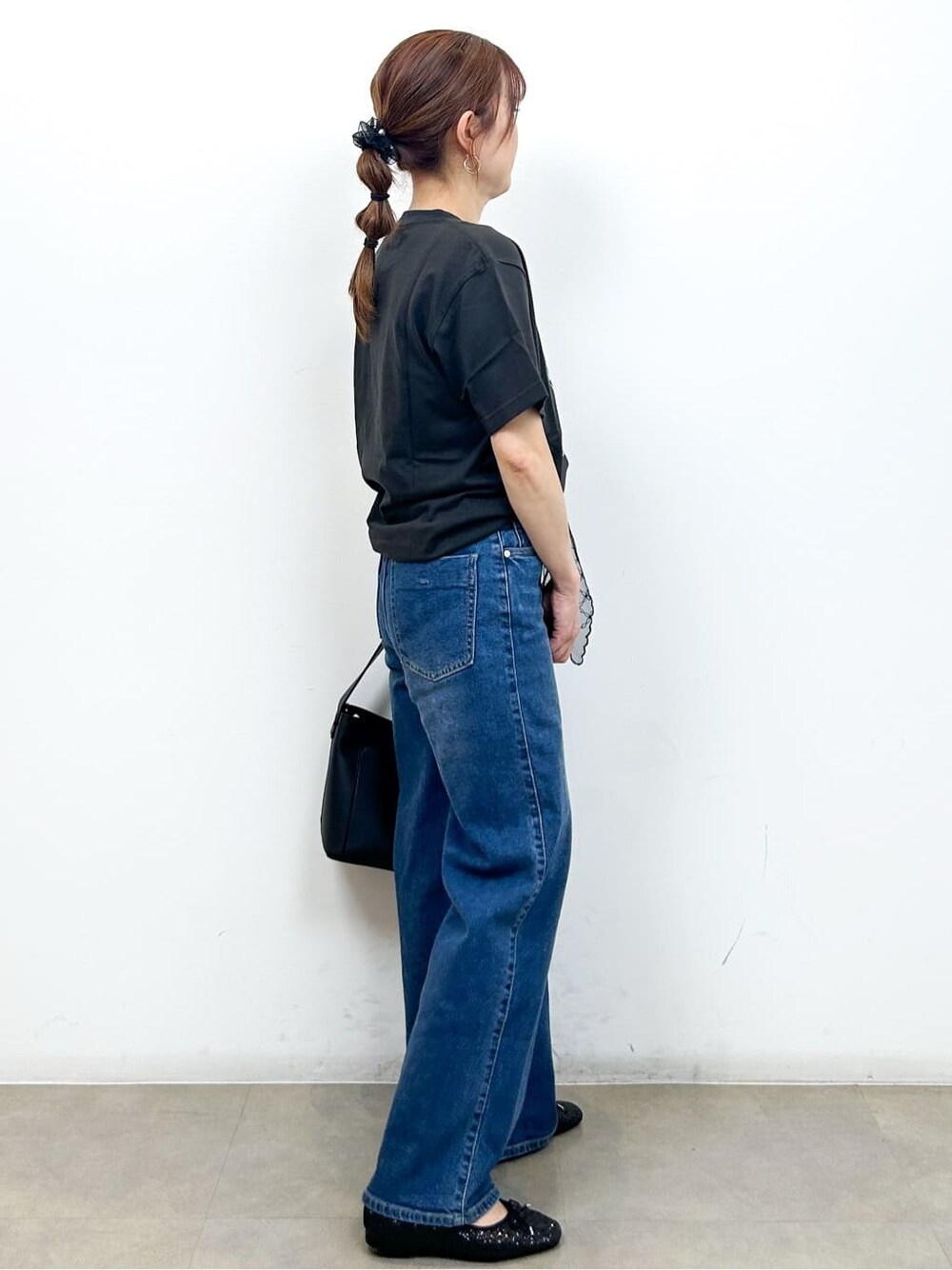 グレー系のTシャツ/カットソー、ブルー系のデニムパンツ、ブラック系のショルダーバッグを着用したレディースの秋コーディネートの8枚目の写真