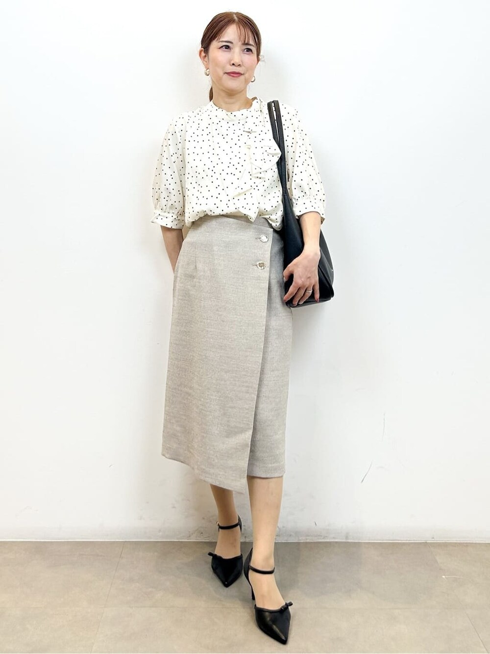ベージュ系のシャツ/ブラウス、ベージュ系のスカート、ブラック系のトートバッグを着用したレディースの夏コーディネートの2枚目の写真