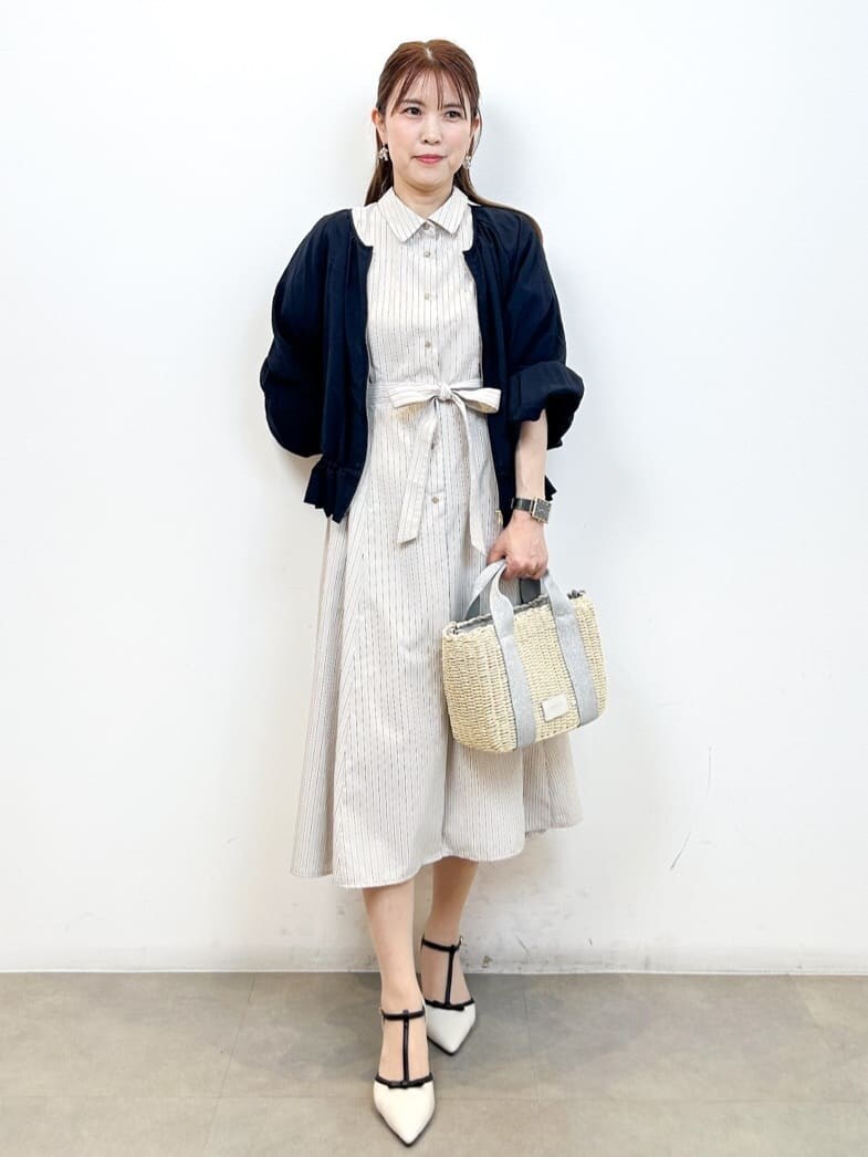 ブルー系のブルゾン、ベージュ系のワンピース、シルバー系のショルダーバッグを着用したレディースの春コーディネートの3枚目の写真
