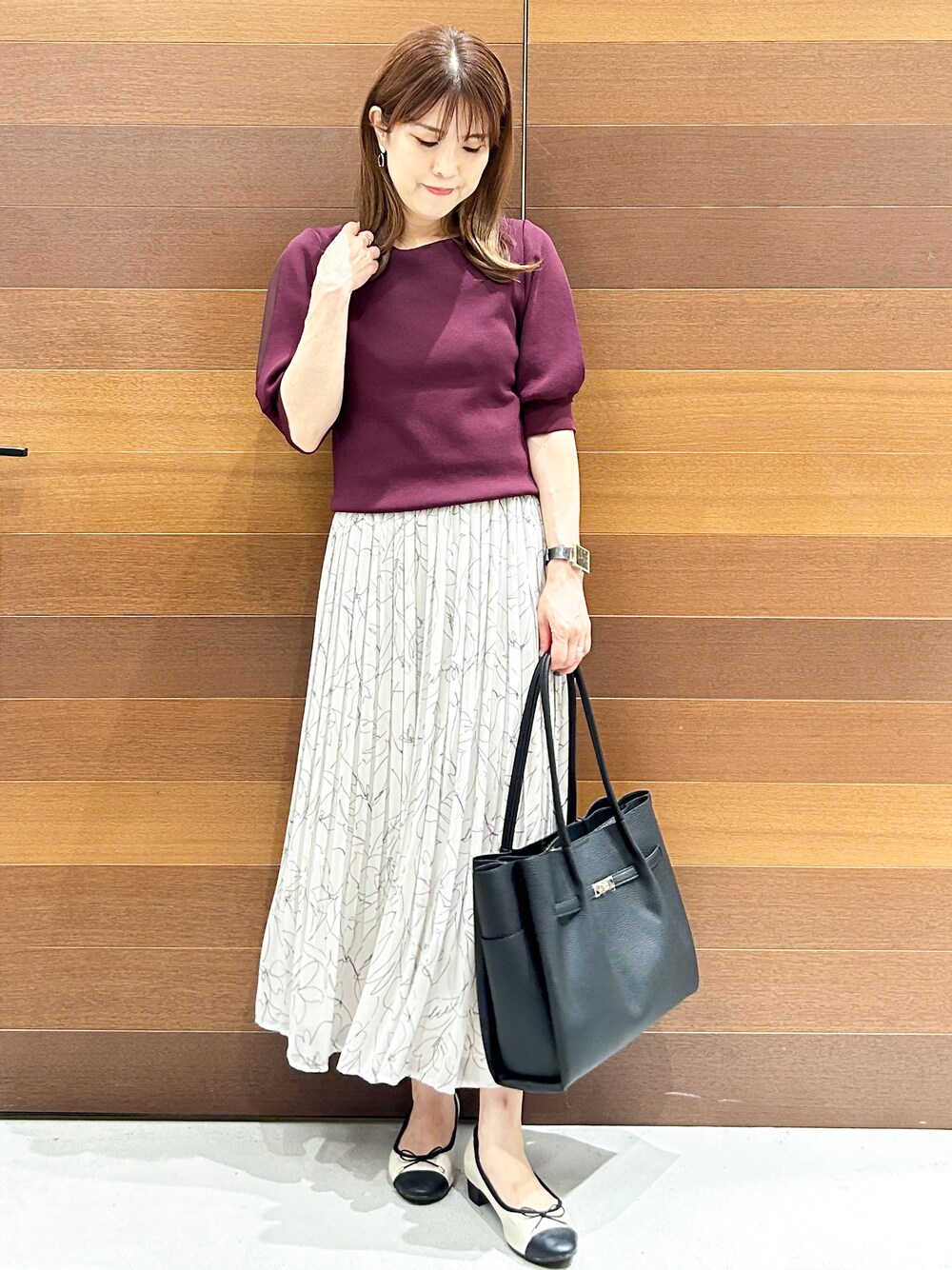 ブラック系のトートバッグ、ベージュ系のパンプスを着用したレディースの夏コーディネートの3枚目の写真