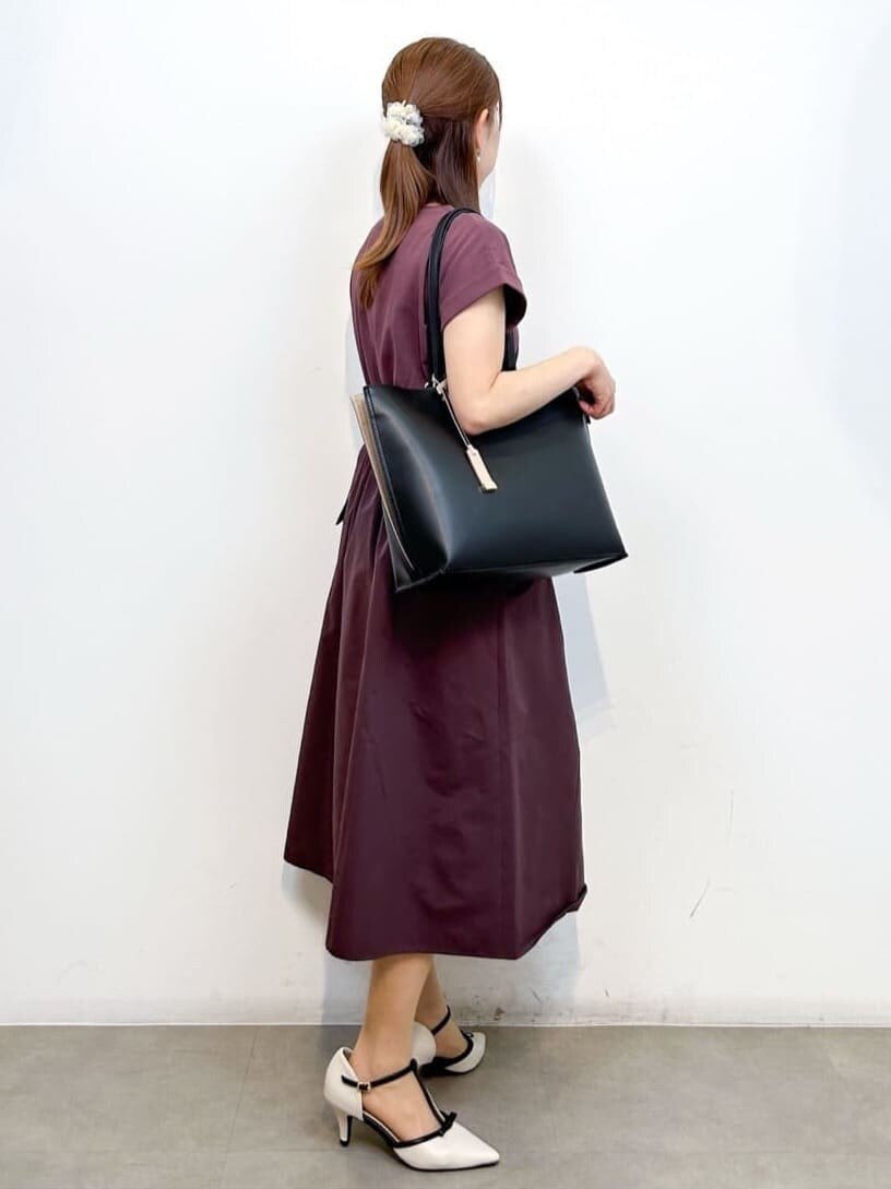 ブラウン系のワンピース、ブラック系のトートバッグ、ホワイト系のパンプスを着用したレディースの夏コーディネートの4枚目の写真