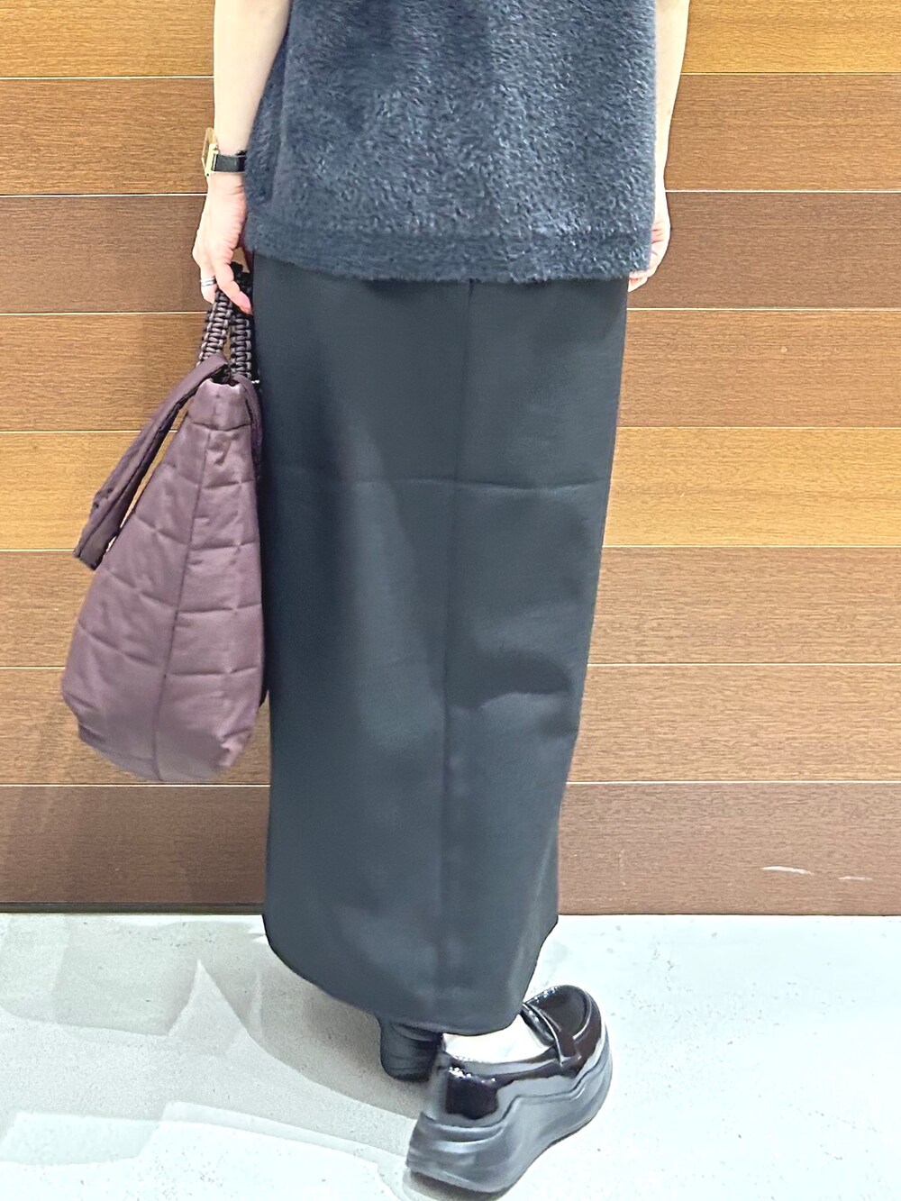 グレー系のニット/セーター、ブルー系のシャツ/ブラウス、ブラック系のスカートを着用したレディースの秋コーディネートの10枚目の写真