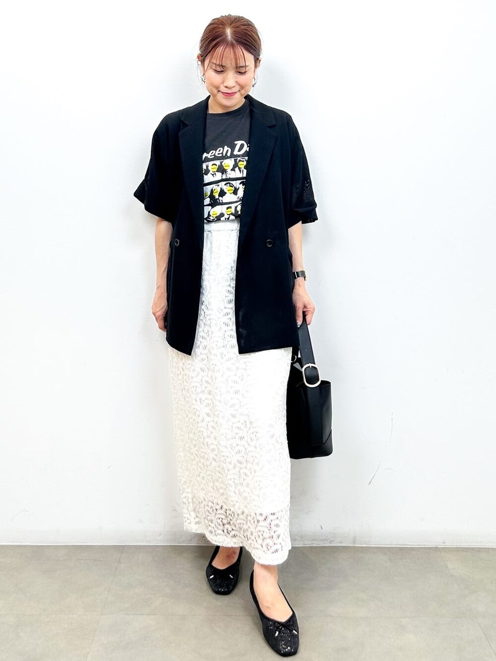ブラック系のテーラードジャケット、グレー系のTシャツ/カットソー、ホワイト系のスカートを着用したレディースの夏コーディネートの2枚目の写真