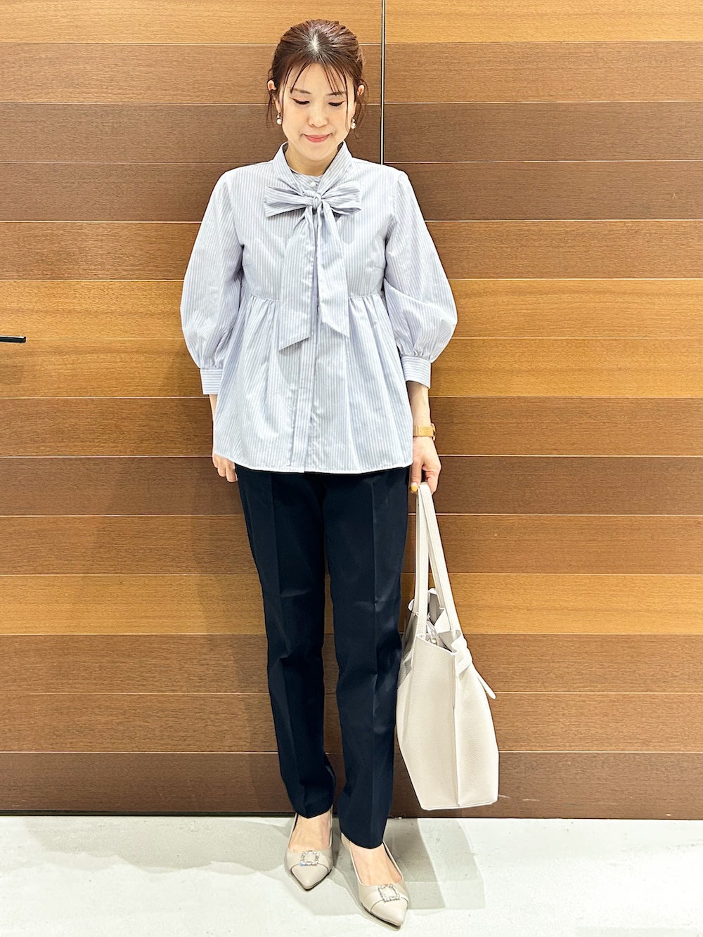ベージュ系のパンプス、ブルー系のシャツ/ブラウス、グレー系のトートバッグを着用したレディースの春コーディネートの4枚目の写真