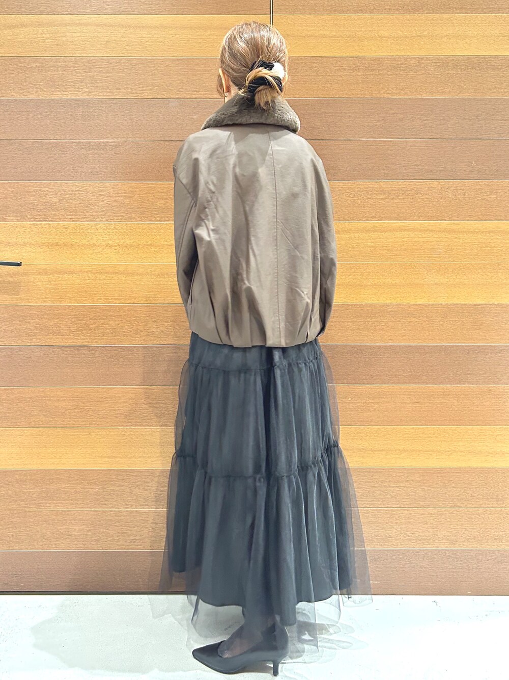 ブラウン系のブルゾン、ホワイト系のTシャツ/カットソー、ブラック系のスカートを着用したレディースの秋コーディネートの5枚目の写真