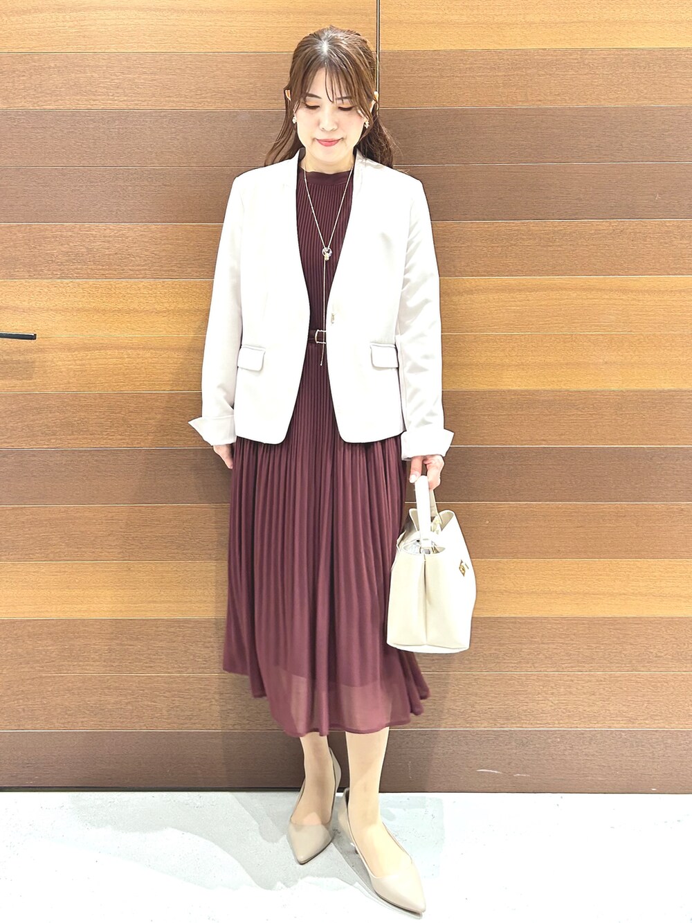 レッド系のワンピース、ホワイト系のハンドバッグ、レッド系のパンプスを着用したレディースの秋コーディネートの10枚目の写真