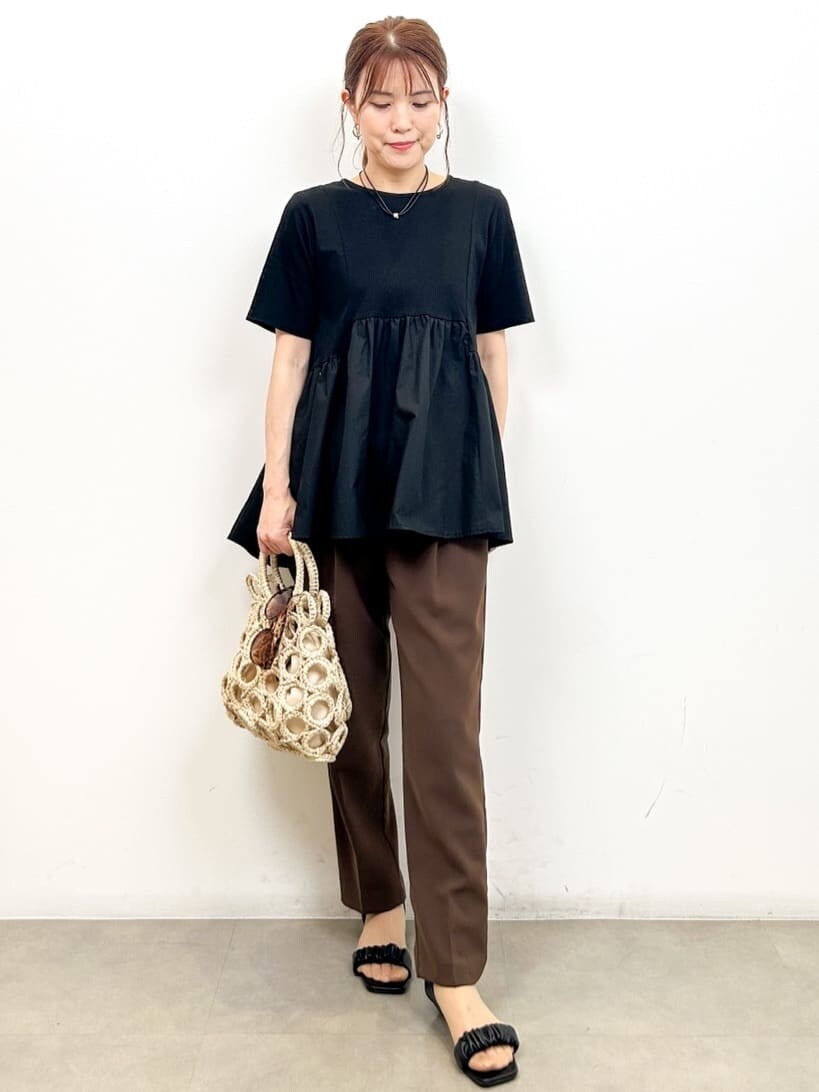 ブラック系のTシャツ/カットソー、ブラウン系のその他パンツ、ホワイト系のハンドバッグを着用したレディースの夏コーディネートの2枚目の写真