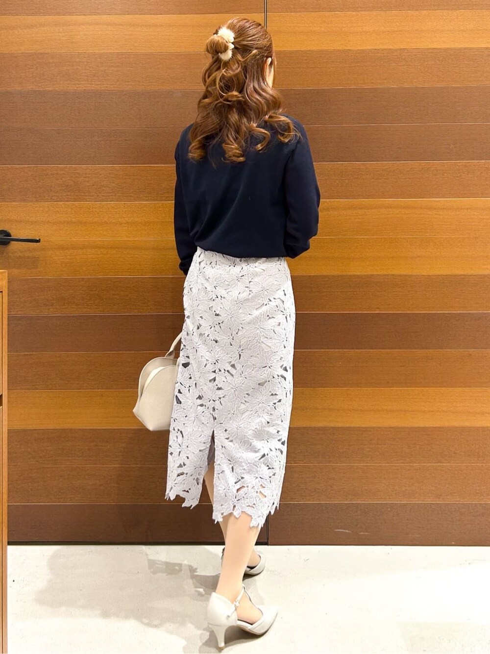 ブルー系のニット/セーター、ブルー系のスカート、ベージュ系のボストンバッグを着用したレディースの春コーディネートの5枚目の写真