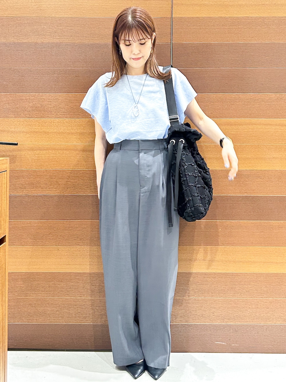 ブルー系のニット/セーター、グレー系のその他パンツ、ブラック系のトートバッグを着用したレディースの夏コーディネートの7枚目の写真