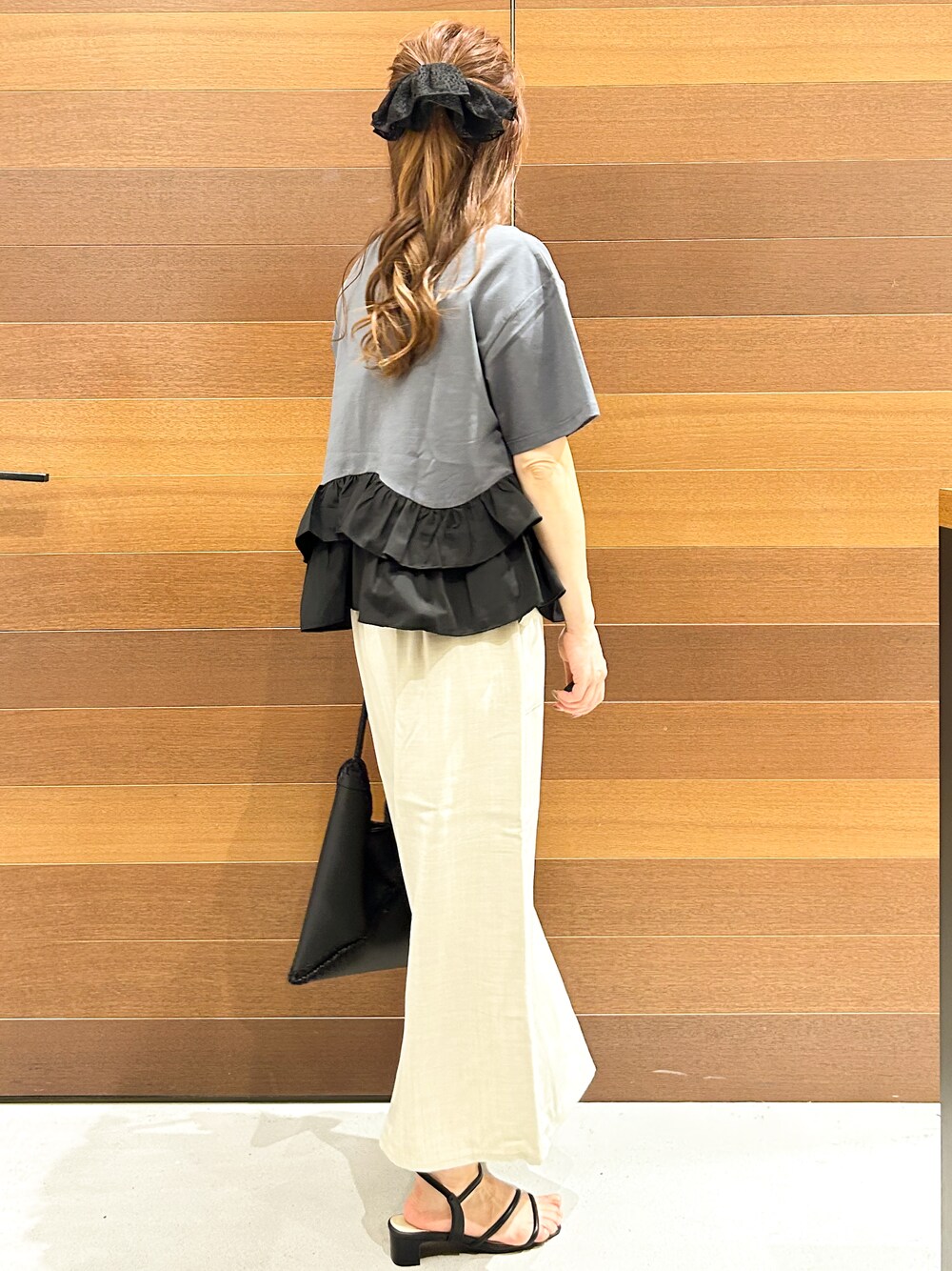 グレー系のTシャツ/カットソー、ベージュ系のスカート、ブラック系のハンドバッグを着用したレディースの夏コーディネートの7枚目の写真