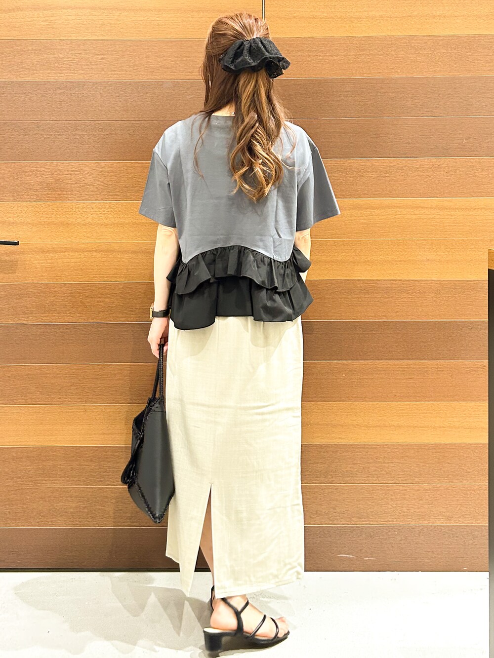 グレー系のTシャツ/カットソー、ベージュ系のスカート、ブラック系のハンドバッグを着用したレディースの夏コーディネートの6枚目の写真