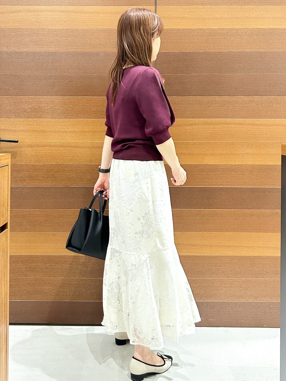 ホワイト系のスカート、ブラック系のトートバッグ、ベージュ系のパンプスを着用したレディースの夏コーディネートの5枚目の写真