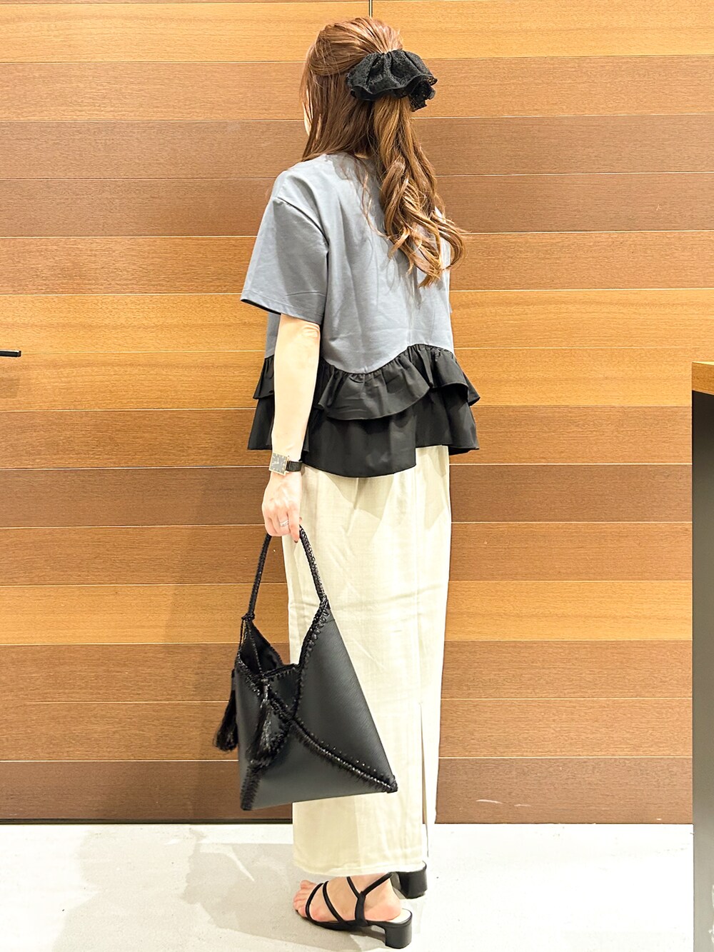 グレー系のTシャツ/カットソー、ベージュ系のスカート、ブラック系のハンドバッグを着用したレディースの夏コーディネートの5枚目の写真