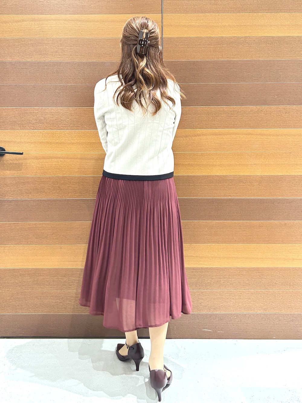 ベージュ系のノーカラージャケット、レッド系のワンピース、ホワイト系のハンドバッグを着用したレディースの秋コーディネートの6枚目の写真