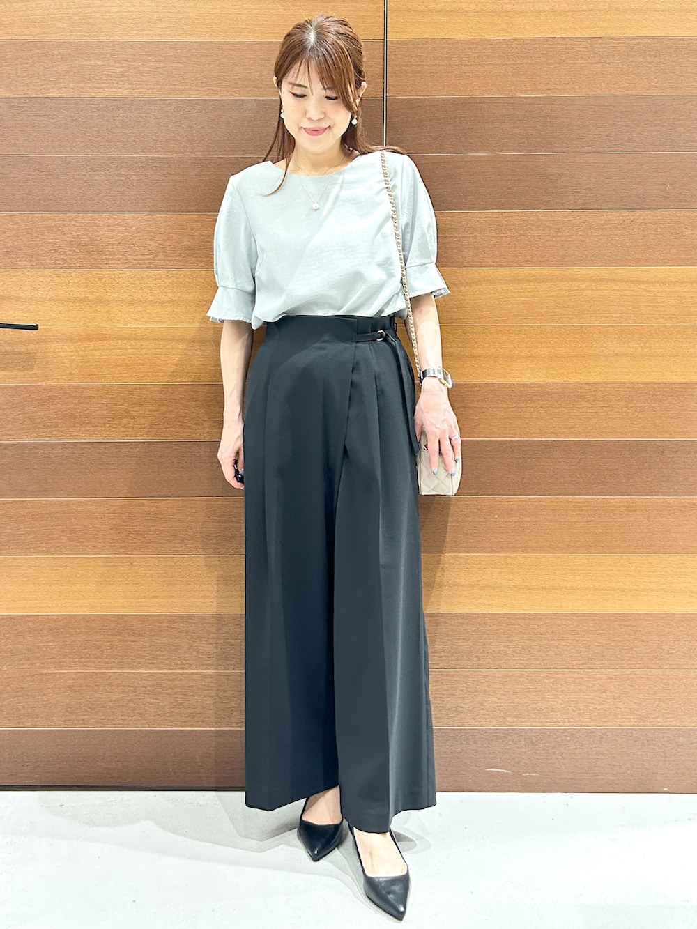 グリーン系のシャツ/ブラウス、ブラック系のその他パンツ、ベージュ系のショルダーバッグを着用したレディースの夏コーディネートの3枚目の写真