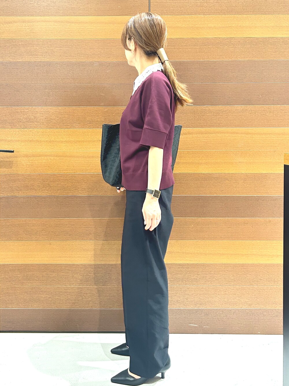 レッド系のニット/セーター、ブラック系のその他パンツ、ブラック系のトートバッグを着用したレディースの秋コーディネートの6枚目の写真