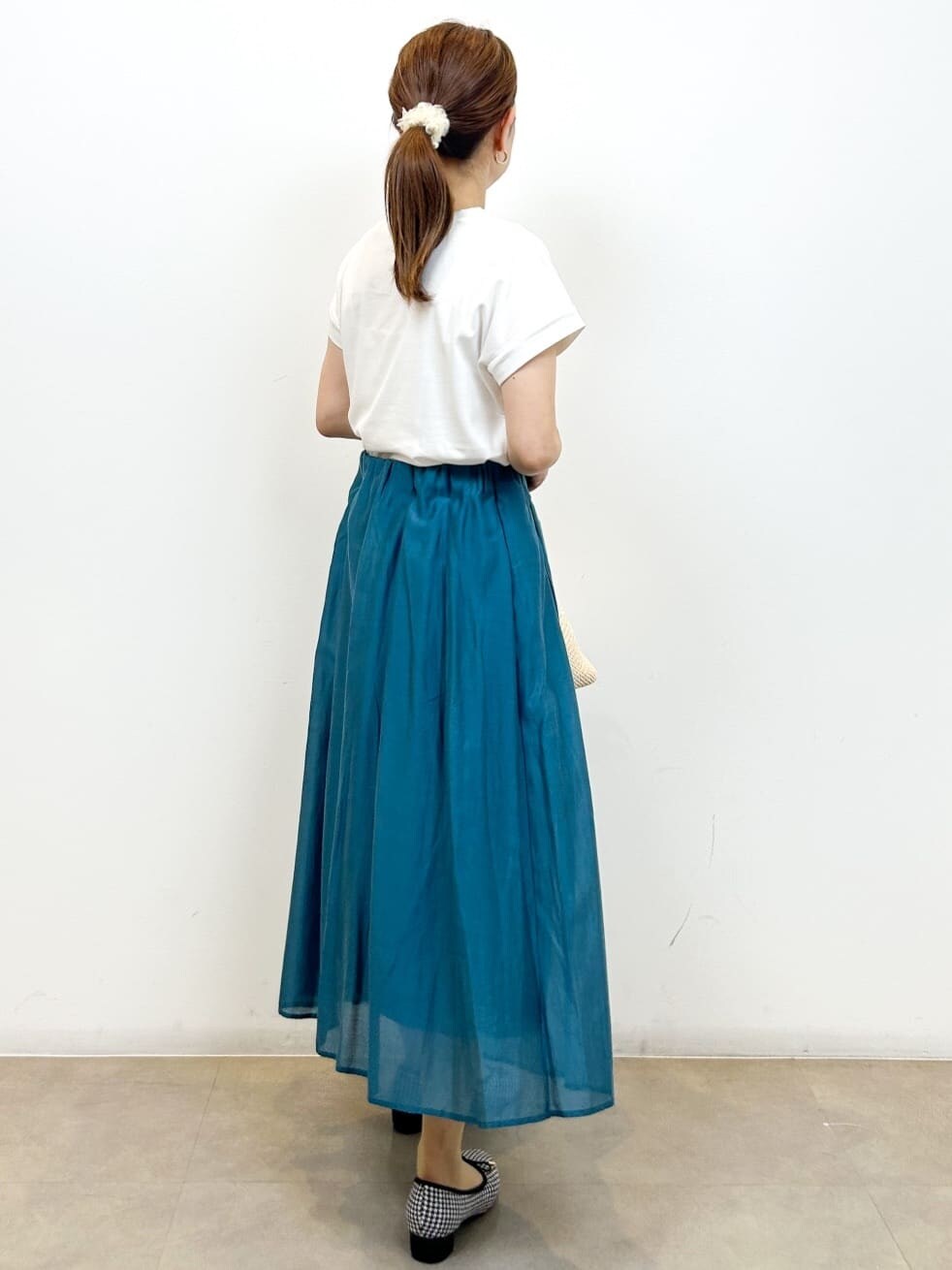 ホワイト系のTシャツ/カットソー、ブルー系のスカート、ブラック系のトートバッグを着用したレディースの夏コーディネートの8枚目の写真