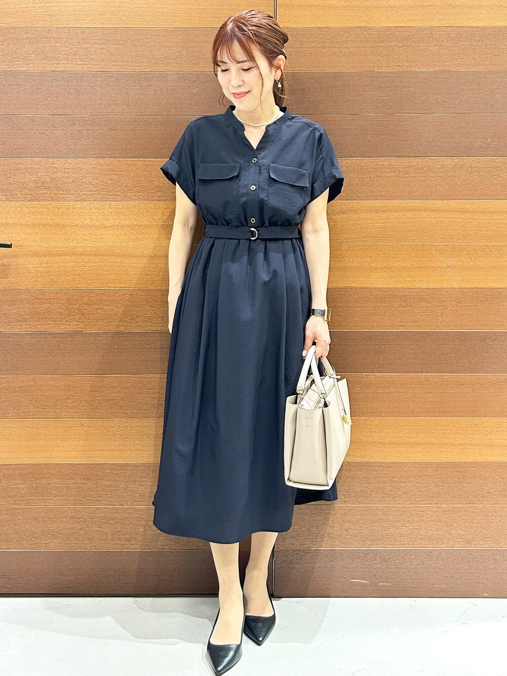 ブルー系のワンピース、ベージュ系のトートバッグ、ブラック系のパンプスを着用したレディースの夏コーディネートの3枚目の写真