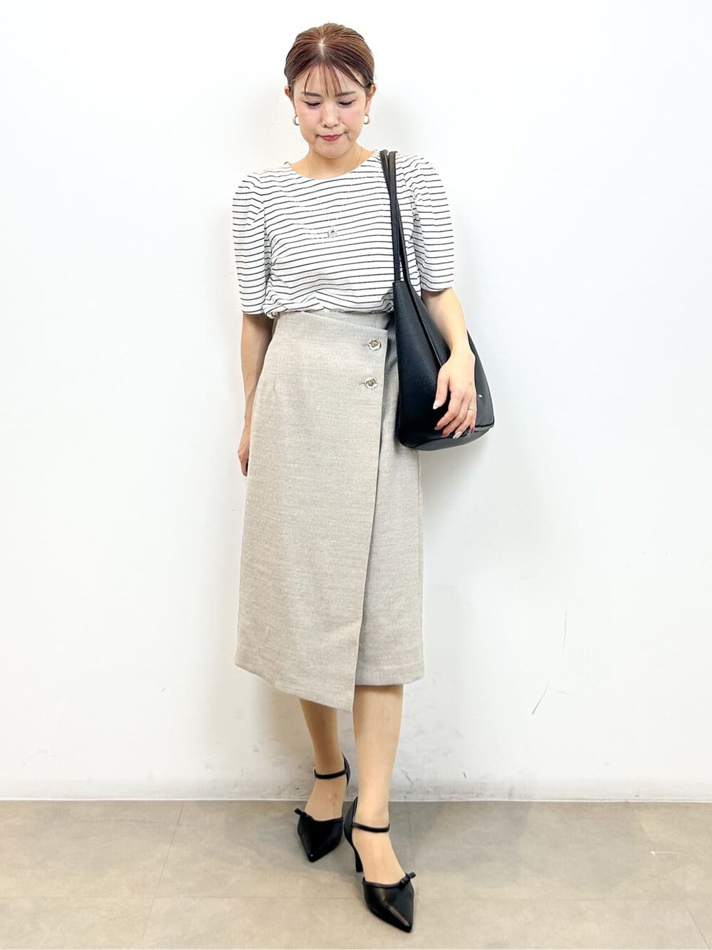 ホワイト系のTシャツ/カットソー、ベージュ系のスカート、ブラック系のトートバッグを着用したレディースの夏コーディネートの5枚目の写真