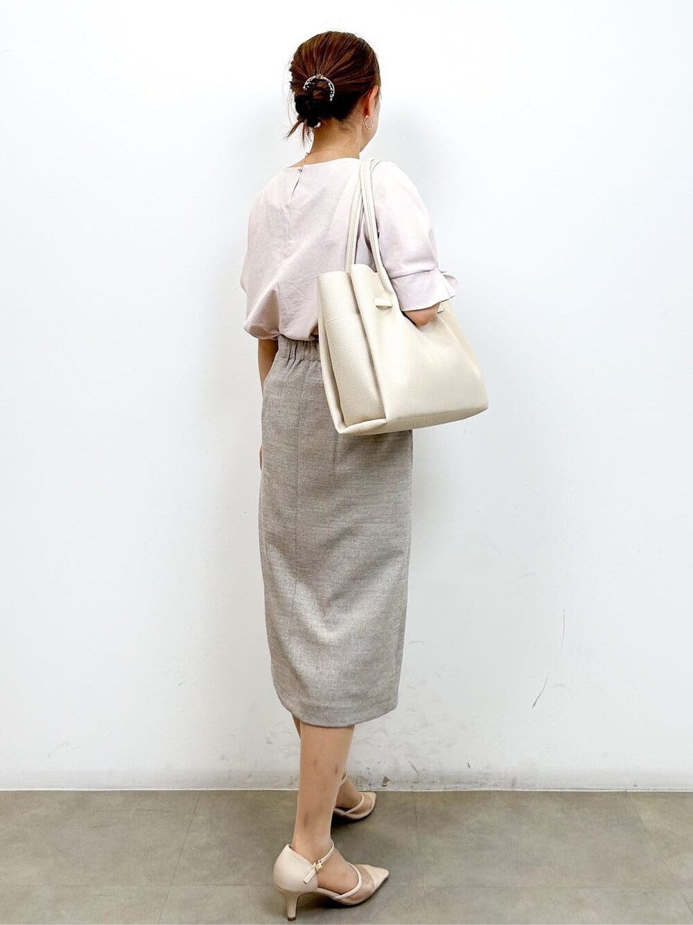 ピンク系のシャツ/ブラウス、ベージュ系のスカート、ホワイト系のトートバッグを着用したレディースの夏コーディネートの4枚目の写真