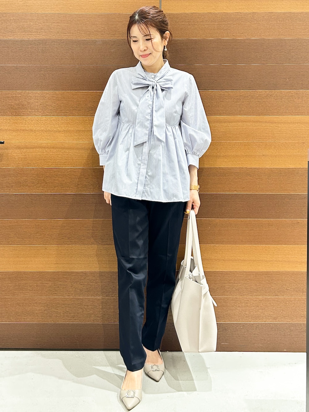 ベージュ系のパンプス、ブルー系のシャツ/ブラウス、グレー系のトートバッグを着用したレディースの春コーディネートの3枚目の写真