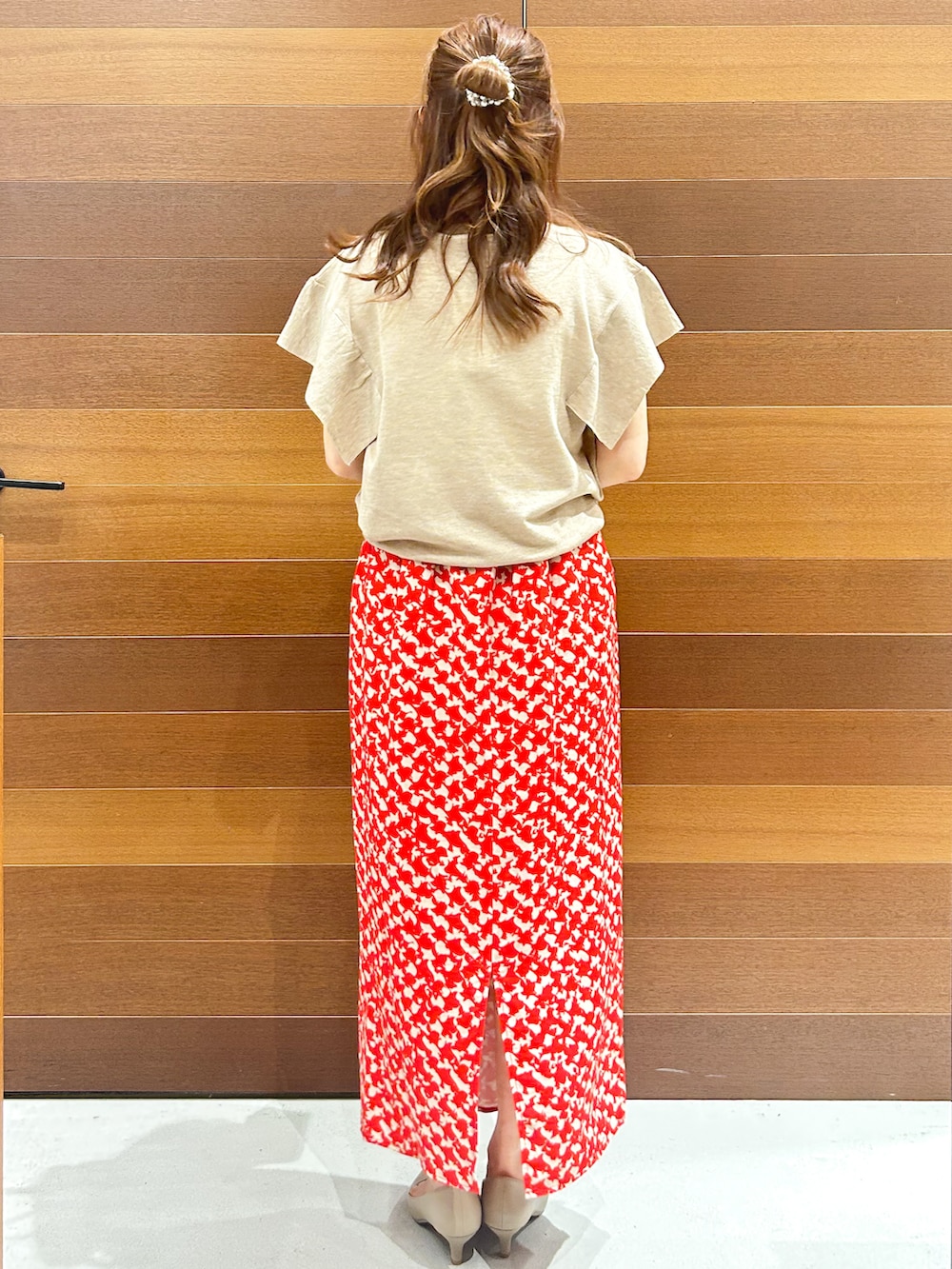 ベージュ系のニット/セーター、レッド系のスカート、グレー系のボストンバッグを着用したレディースの夏コーディネートの6枚目の写真