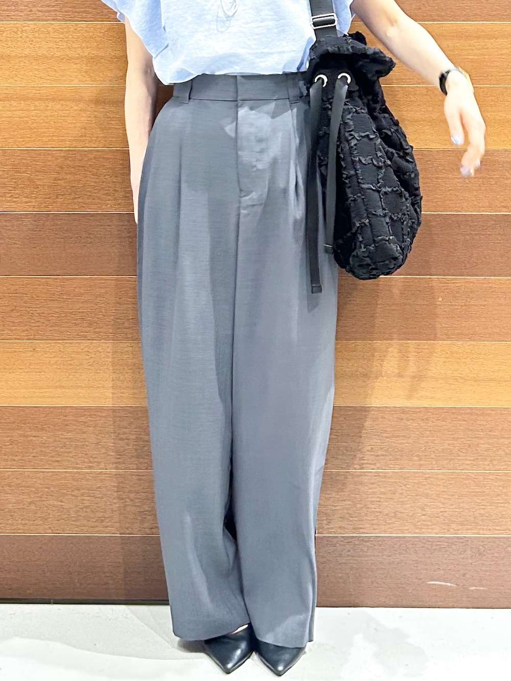 ブルー系のニット/セーター、グレー系のその他パンツ、ブラック系のトートバッグを着用したレディースの夏コーディネートの8枚目の写真