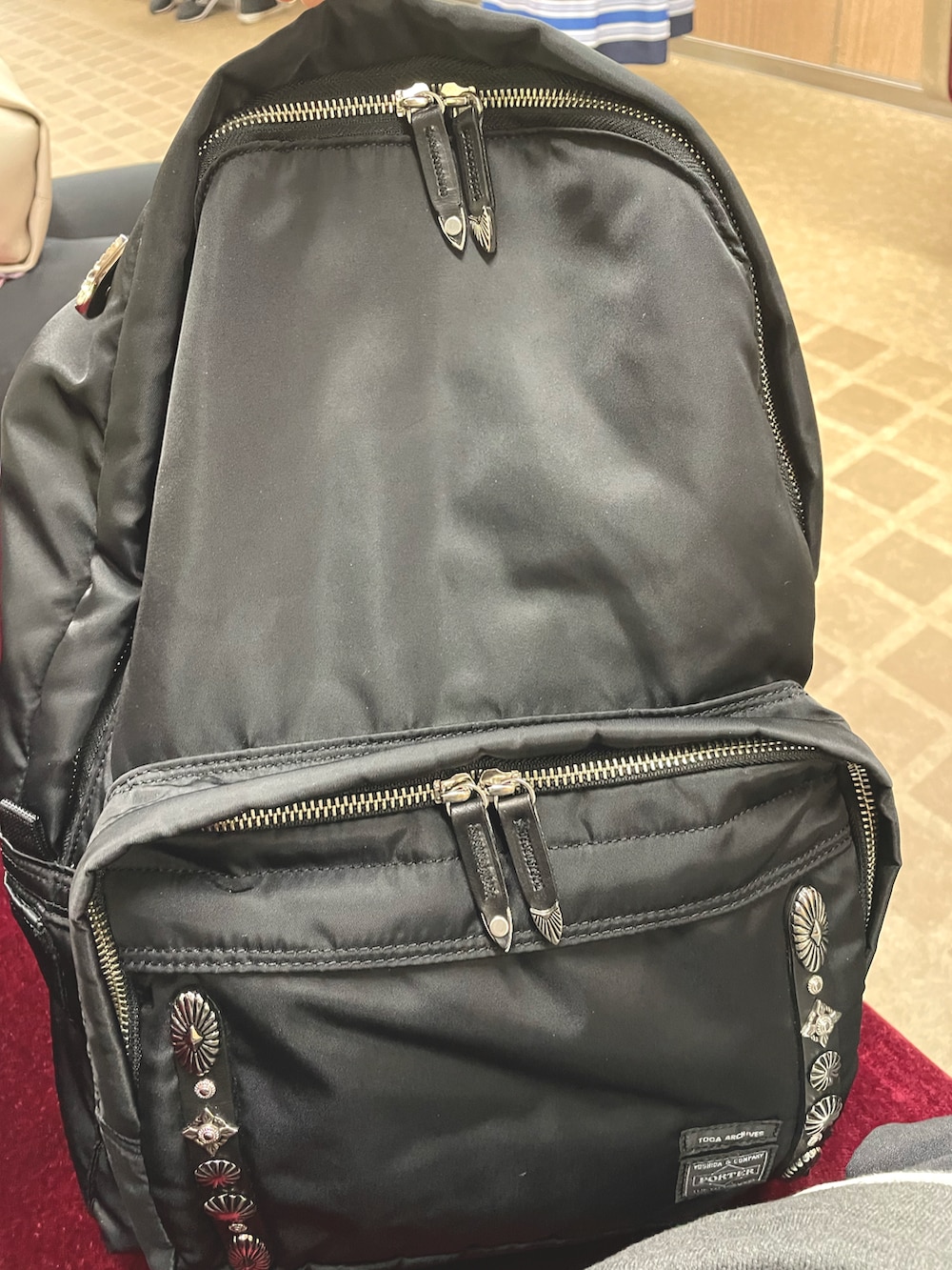 グレー系のパンツ、グレー系のスニーカー、ブラック系のバックパック/リュックを着用したメンズの夏コーディネートの2枚目の写真