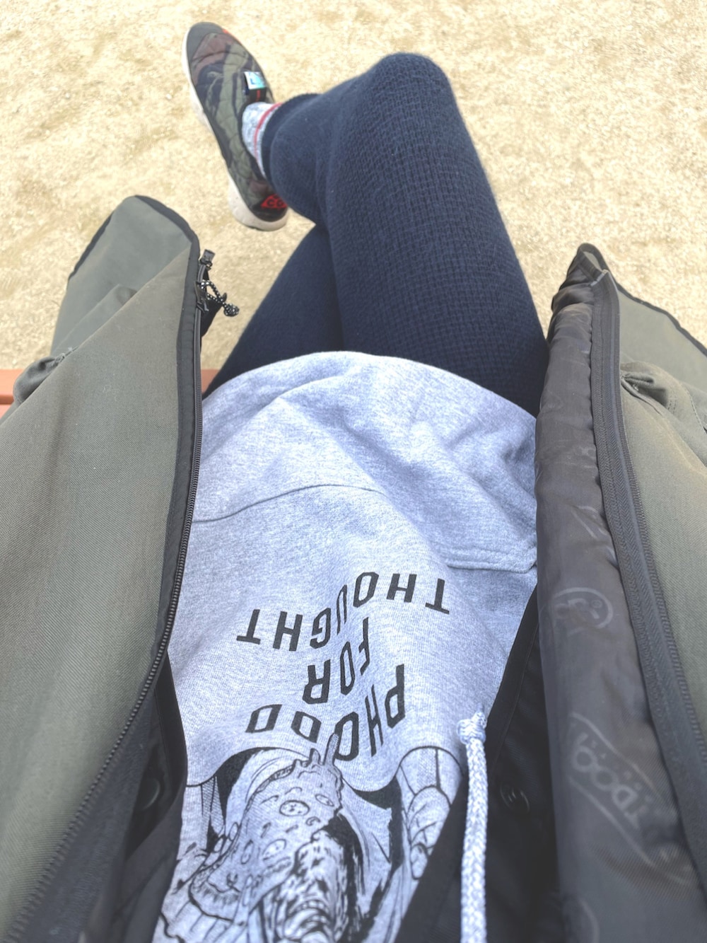 グリーン系のノーカラーコート、グリーン系のスニーカー、ブルー系のその他パンツを着用したメンズの冬コーディネートの2枚目の写真