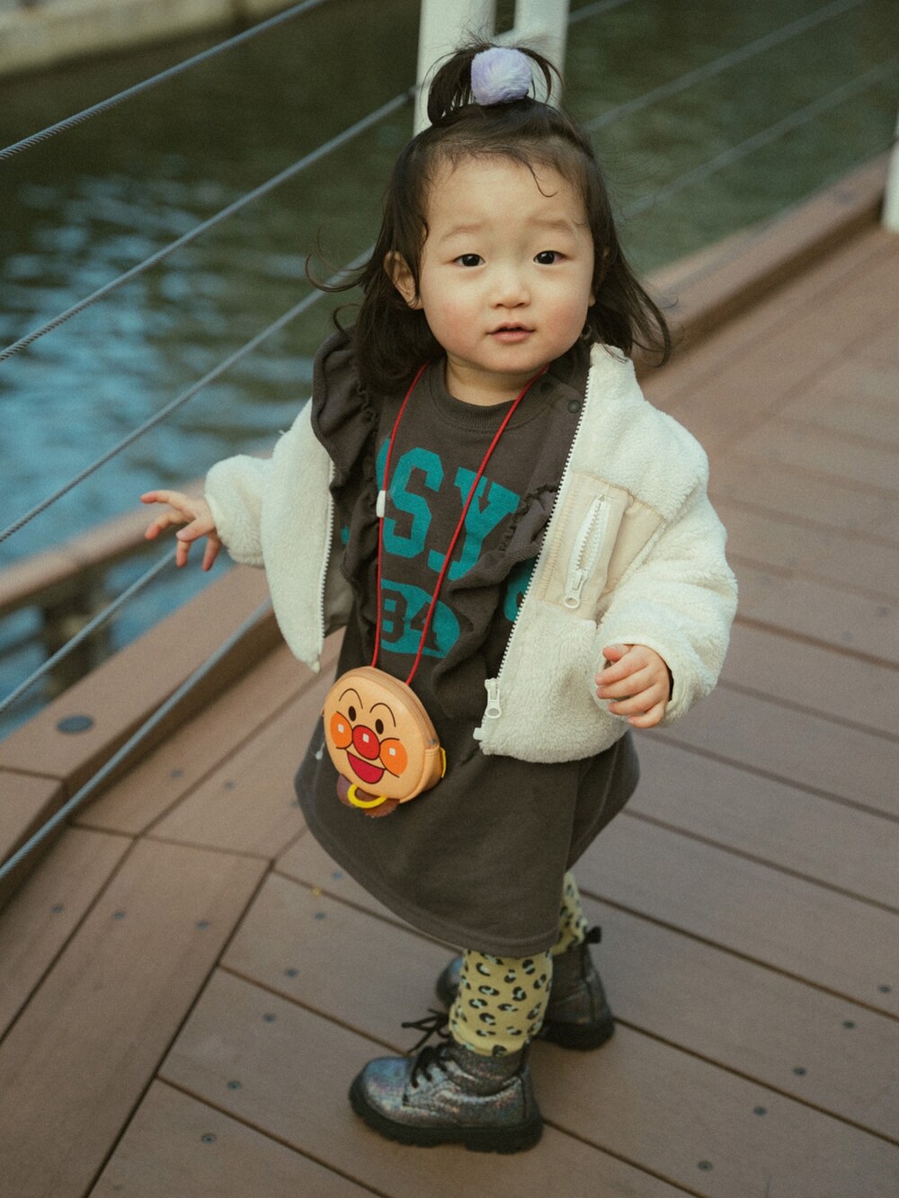グレー系のワンピース、ブラック系のブーツを着用したキッズの冬コーディネートの2枚目の写真