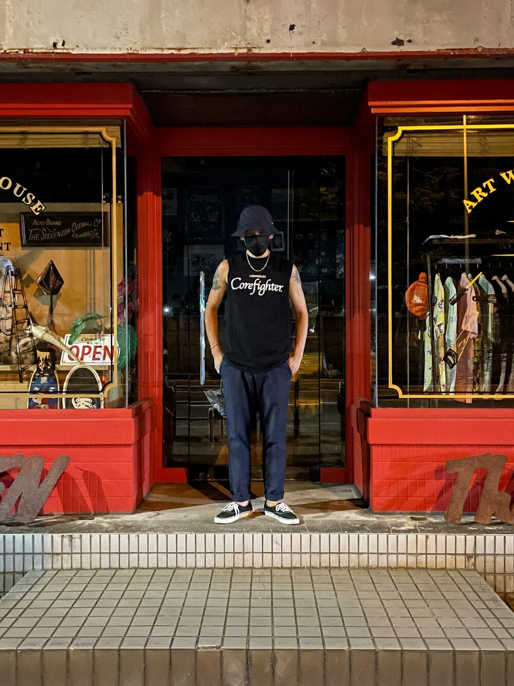 ブラック系のタンクトップ、ブルー系のチノパンツ、ブラック系のスニーカーを着用したメンズの冬コーディネートの2枚目の写真