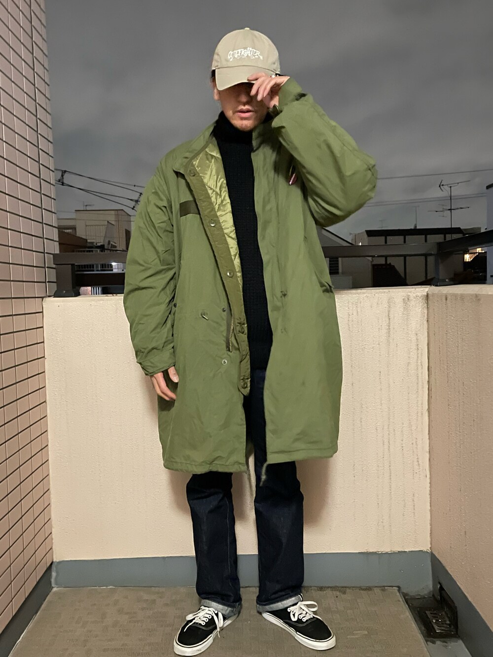 ブラック系のニット/セーター、ブルー系のデニムパンツ、ブラック系のスニーカーを着用したメンズの冬コーディネートの2枚目の写真