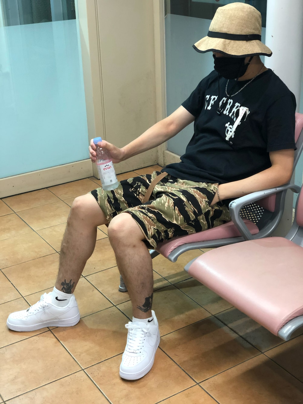 ブラック系のTシャツ/カットソー、グリーン系のカーゴパンツ、ホワイト系のスニーカーを着用したメンズの秋コーディネートの3枚目の写真
