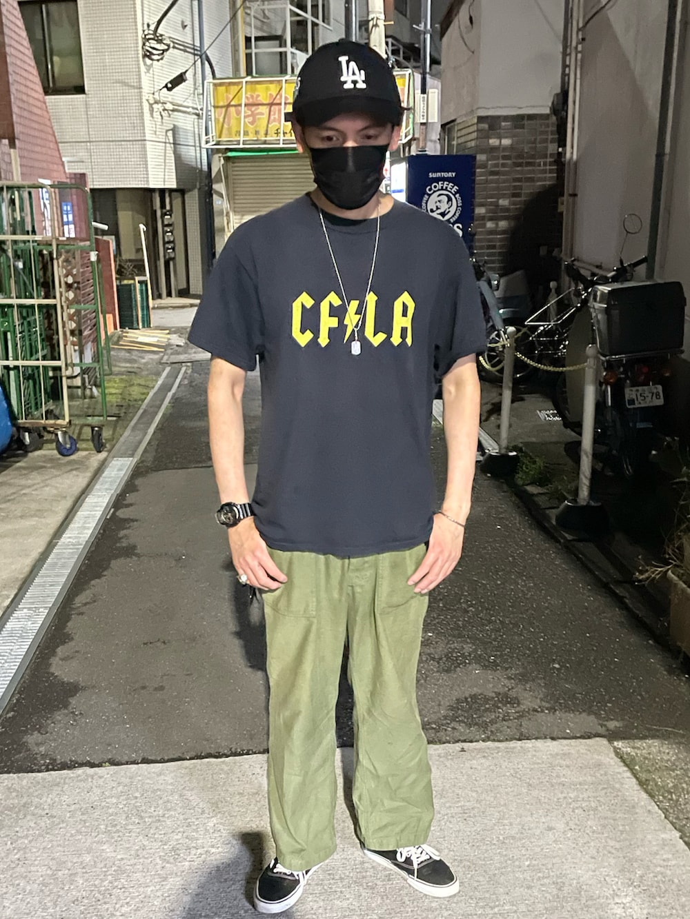ブラック系のTシャツ/カットソー、グリーン系のカーゴパンツ、ブラック系のスニーカーを着用したメンズの冬コーディネートの2枚目の写真