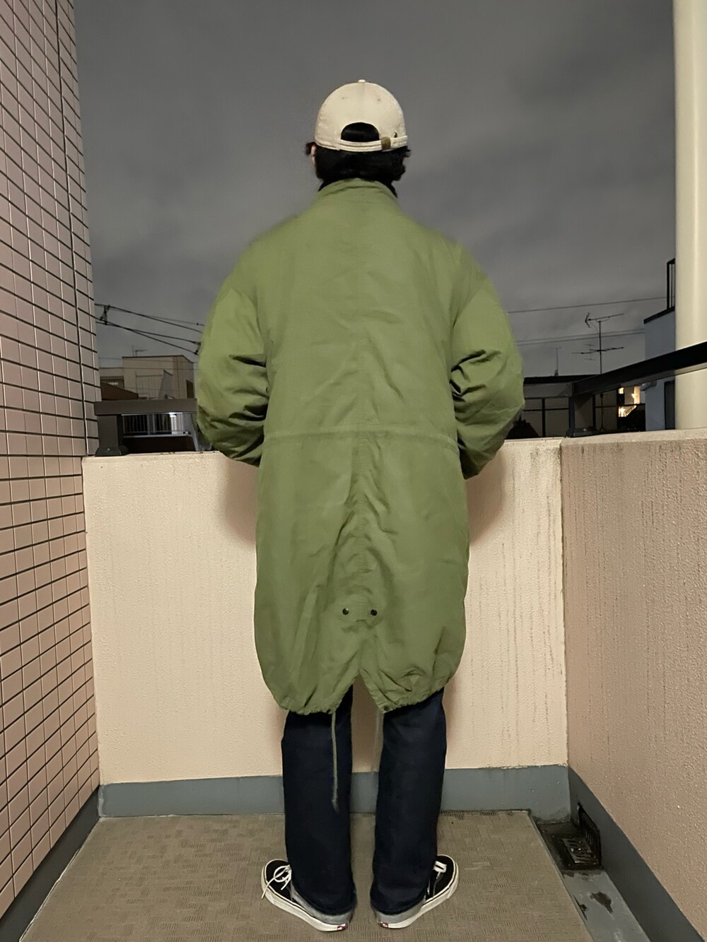ブラック系のニット/セーター、ブルー系のデニムパンツ、ブラック系のスニーカーを着用したメンズの冬コーディネートの4枚目の写真