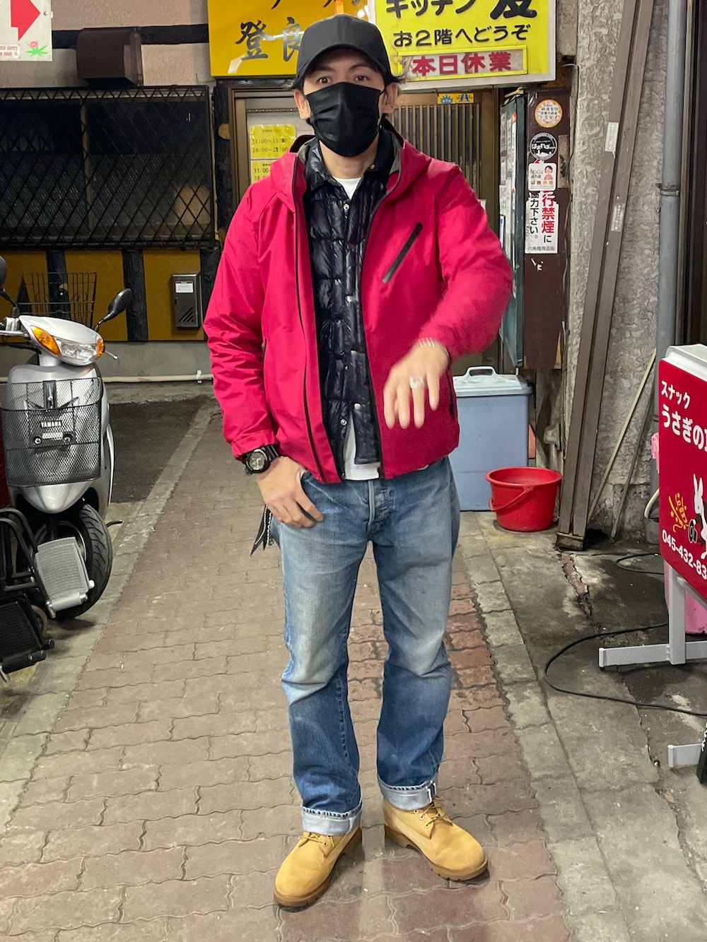 イエロー系のブーツ、ブルー系のデニムパンツ、ブラック系のダウンジャケット/コートを着用したメンズの冬コーディネートの2枚目の写真