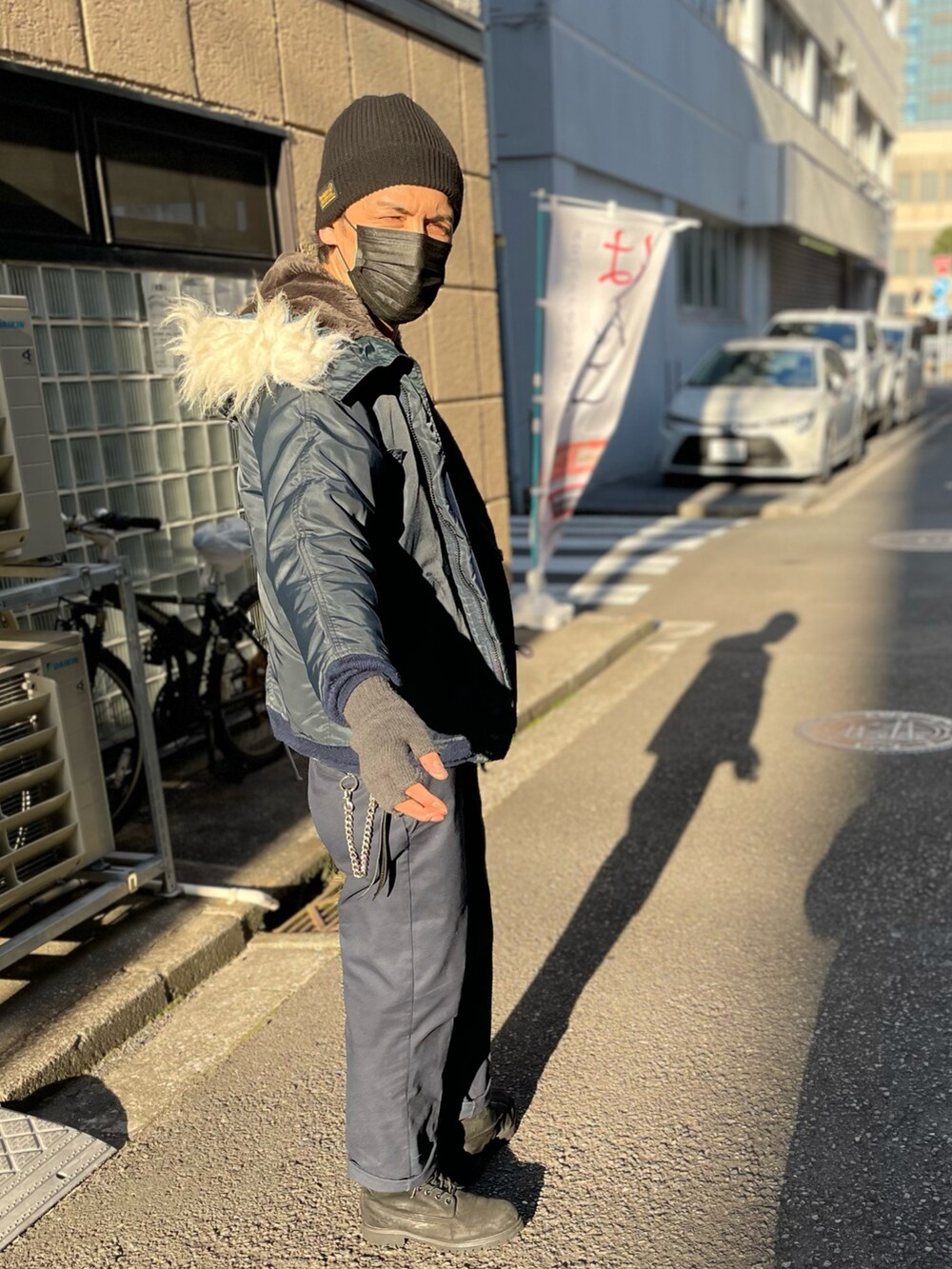 ブルー系のミリタリージャケット、ブルー系のチノパンツ、ブラック系のブーツを着用したメンズの冬コーディネートの3枚目の写真